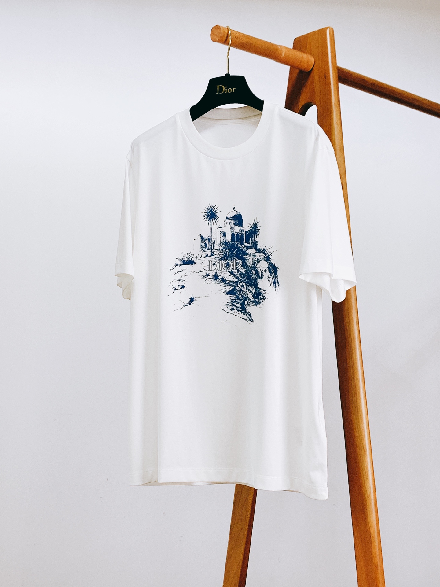 NO:841874,Dior Homme 2026SS new spring and summer sketch landscape printed T-shirt. Customized high-count double-strand mercerized cotton fabric, which feels silky and skin-friendly, has a soft and bright luster, and the upper body is soft and draped without sticking to the skin. The fabric has been pre-shrunk and anti-pilling, so it will not deform or pill after being washed for a long time. It has excellent moisture absorption and perspiration, so you can wear it all day long in summer without feeling stuffy and sweaty.  Classic round neck + double thread rib seaming, the neckline is not easy to curl and deform after long-term wear. The architectural landscape print on the chest uses highly reactive environmentally friendly ink to restore the texture of hand-drawn sketches. The lines are fine and clear, and the color reproduction is high. It is not easy to crack and fall off after multiple washings. It is low-key and noble. The slightly loose tailoring does not flatter the figure, available in black/white, the same style for men and women. …………………………………………………… SizeM-5XL, dior, dior, tees, t-shirt,19860909Dior Homme 迪奥·桀傲 2026SS春夏新品 素描风景印花T恤. 定制高支双股丝光棉面料,触感丝滑亲肤,自带柔亮光泽,上身软糯垂坠不贴肤.面料做了预缩定型与抗起球处理,久洗不变形不起球,吸湿排汗超优秀,夏天穿一整天都清爽不闷汗. 经典圆领+双股线罗纹锁边,领口久穿不易卷边变形,胸前的建筑风景印花采用高活性环保油墨,还原手绘素描质感,线条细腻清晰,色彩还原度高,多次洗涤也不易开裂脱落,低调又显贵.微宽松剪裁不挑身材,黑/白两色可选,男女同款. …………………………………………………… SizeM-5XL,,dior,dior,tees，t-shirt,,Men's clothing