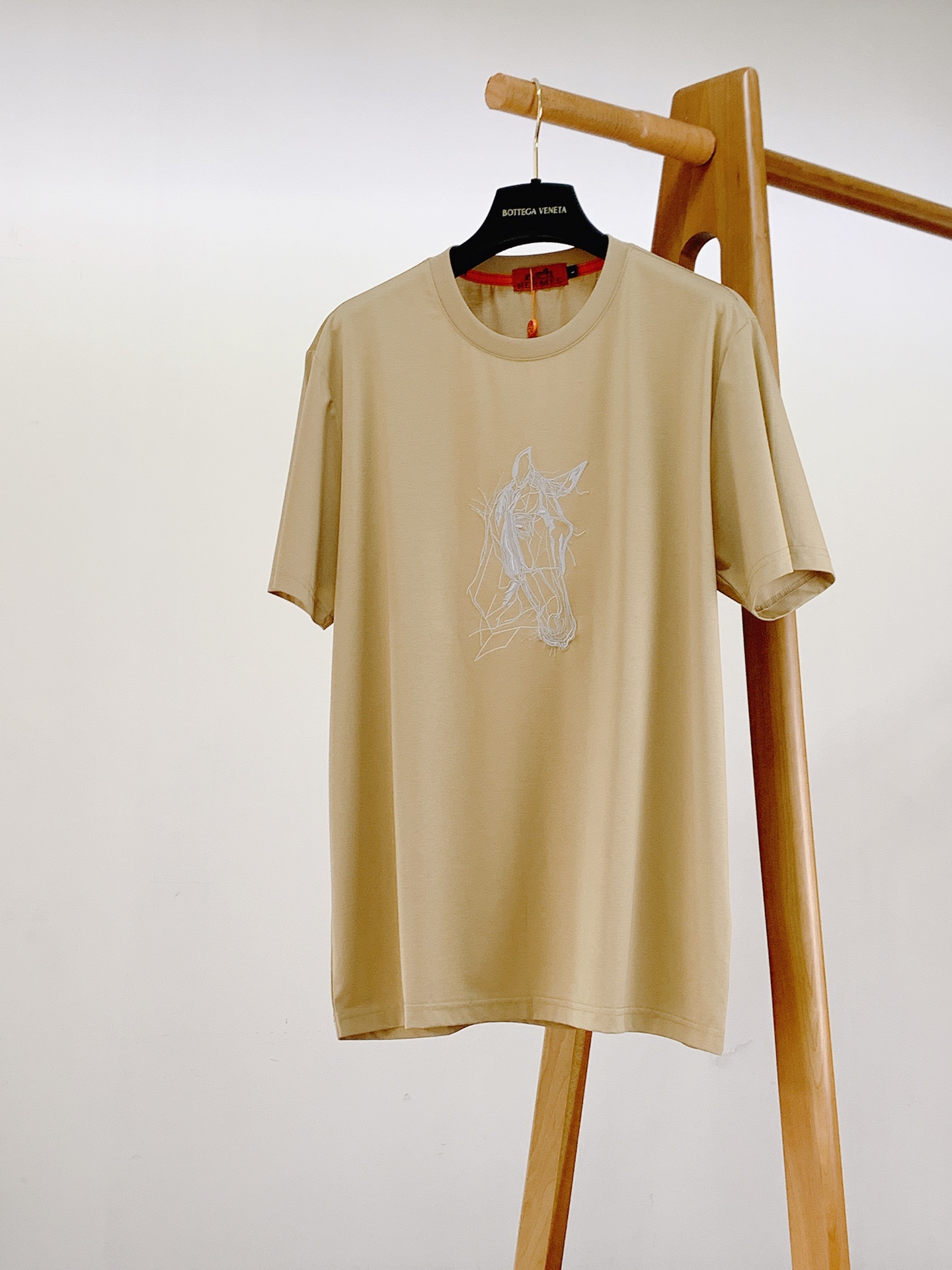 NO:841881,Hermès 2026SS new product for spring and summer, abstract horse embroidered short-sleeved T-shirt, a new interpretation of the brand's classic equestrian elements, minimalist lines outline an artistic horse silhouette, and directly enhances the sense of luxury.  The high-count mercerized cotton fabric is selected, with a smooth and silky touch. The upper body is breathable and not sweaty. It is not easy to deform and turn yellow after being worn for a long time. The three colors of black/white/khaki are low-key and noble. You can wear it with your eyes closed without stepping on the thunder. The three-dimensional embroidery on the chest is fully stretched, the stitching is fine and flat, the lines are neat and not frizzy, and the details show the brand texture. It is paired with the brand's iconic orange-red woven label, which is low-key and recognizable.  The slightly loose straight fit is not flattering on your body shape, and can be easily worn by both men and women. Whether worn alone or layered, it has a high-end feel. It is a versatile style that will never go out of style in your wardrobe. Just close your eyes and wear it!  ……………………………………………………………… SizeM-3XL,,hermes,hermes,T-shirt,tees,t-shirt,19860909Hermès 爱马仕 2026SS春夏新品 抽象骏马刺绣短袖T恤,品牌经典马术元素的全新演绎,极简线条勾勒出艺术感十足的骏马轮廓,高级感直接拉满. 甄选高支丝光棉面料,触感丝滑垂顺,上身透气不闷汗,久穿也不易变形发黄,黑/白/卡其三色都是低调又显贵的百搭色系,闭眼入不踩雷. 胸前的立体刺绣工艺拉满,针脚细密平整,线条利落不毛躁,细节处尽显品牌质感,搭配品牌标志性橙红色织唛,低调又有辨识度. 微宽松直筒版型不挑身材,男女同款都能轻松驾驭,不管是单穿还是叠穿都自带高级感,属于衣柜里永不过时的百搭款,闭眼入就对了！ …………………………………………………… SizeM-3XL,,hermes,hermes,T-shirt,tees，t-shirt,,Men's clothing