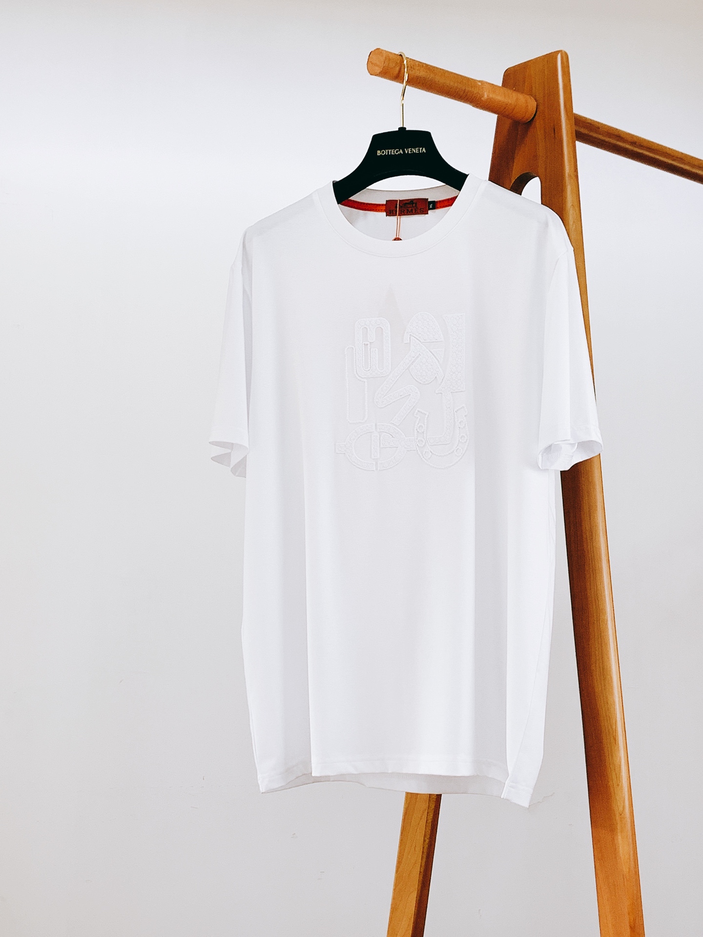 NO:841893,Hermès 2026SS new spring and summer short-sleeved T-shirt with embroidered equestrian elements is a new interpretation of the brand's classic equestrian genes. The three-dimensional embroidery of the same color is low-key and hidden in ingenuity, and directly adds a sense of luxury. The high-count mercerized cotton fabric is selected, with a silky and smooth touch. The upper body is breathable and not sweaty. It is not easy to deform and turn yellow after being worn for a long time. Both black and white are low-key and noble, versatile colors, so you won't step on the thunder if you close your eyes.  The high-density terry embroidery on the chest is fully stretched, the stitching is fine and flat, the pattern texture is clear and three-dimensional, and the color collision with the body is both recognizable and low-key. It is matched with the brand's iconic orange-red woven label, and the brand texture is fully displayed in the details. The slightly loose straight version is not flattering on the figure, and it has a sense of luxury whether worn alone or layered. It is a versatile style that will never go out of style in the wardrobe. Just close your eyes and enjoy it!  ……………………………………………………………… SizeM-3XL,,hermes,hermes,T-shirt,tees,t-shirt,19860909Hermès 爱马仕 2026SS春夏新品 马术元素刺绣短袖T恤,品牌经典马术基因的全新演绎,同色系立体刺绣低调暗藏巧思,高级感直接拉满. 甄选高支丝光棉面料,触感丝滑垂顺,上身透气不闷汗,久穿也不易变形发黄,黑白两色都是低调又显贵的百搭色系,闭眼入不踩雷. 胸前的高密度毛巾绣工艺拉满,针脚细密平整,图案肌理清晰立体,和衣身的色彩碰撞兼具辨识度与低调质感,搭配品牌标志性橙红色织唛,细节处尽显品牌质感. 微宽松直筒版型不挑身材,不管是单穿还是叠穿都自带高级感,属于衣柜里永不过时的百搭款,闭眼入就对了！ …………………………………………………… SizeM-3XL,,hermes,hermes,T-shirt,tees，t-shirt,,Men's clothing