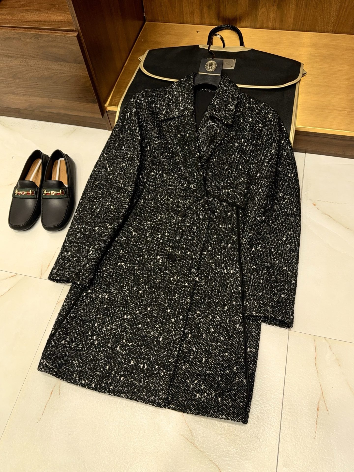 NO:637515,[Unique style star-dot herringbone pattern mixed-color woolen fabric, large notch lapel design, lambskin edge accessories, long windbreaker style coat] Men's long windbreaker style coat, carved in the texture, is unique to your style.  When the texture aesthetics of high-end fabrics meet the precise expression of craftsmanship details, this long trench coat becomes a concrete expression of men's style - rejecting the same winter clothing, using star-dot gauze herringbone mixed-color wool as the base, with the exquisite design of large flat lapel and lambskin binding, so that every inch of tailoring is in line with the gentleman's style, and every detail highlights the unique style. The texture of the fabric has a hidden charm and a deep texture.  The core fabric selects star-dot floral yarn herringbone pattern mixed color woolen, which lays a high-end tone from the raw material spinning and dyeing. The star-dot floral yarn craftsmanship gives the yarn its own natural scattered color spots, abandoning the monotony of solid colors, and the mixed color effect is rich in layers but not messy; the classic herringbone texture is high-density  Weaving, the texture is three-dimensional and clear. It not only has the softness, skin-friendliness and warmth of woolen fabrics, but also has the anti-wrinkle and stiffness of the shape. It has a delicate touch that is within reach, which is the nobleness given by high-end fabrics. The fabric drape naturally when walking, does not collapse or wrinkle, and always maintains a neat shape.  The design is classic and reshaped, and the details are highlighted. The long trench coat-style tailoring inherits the classic long silhouette of the trench coat, and the length is just right to cover the calf. It not only provides sufficient warmth in winter, but also stretches the body proportions vertically. It can be worn tall and tall regardless of body shape. The loose and moderate version design accommodates the lines of shoulders, waist and abdomen, and can be worn with suits or sweaters. It can be seamlessly switched between business and leisure scenes, and can easily adapt to a variety of dressing needs. Large notch lapel design.  The classic large flat lapel collar is polished by hand shaping technology, and the arc of the collar angle is precise and exquisite, neatly outlining the shoulder and neck lines, weakening the bloated feeling of the neck, and showing the strong outline of the men's neck and shoulders; the width of the lapel collar has been repeatedly adjusted to retain the solemnity of the formal collar shape while incorporating the relaxed feeling of the windbreaker. It does not lose style in formal occasions and is casual in daily wear. Lambskin binding technology for accessories  The finishing touch is the lambskin edging accessories - first-layer lambskin is selected, the leather is delicate and flexible, and the luster is natural and moist. It is hand-fitted to key parts such as the edge of the lapel and the side seam of the placket. The fineness of the leather and the thickness of the woolen form a material collision. The cold-toned leather luster neutralizes the heavyness of the woolen, giving the overall shape a few more exquisite details in the calmness. The contrast between the materials in the touch highlights the high-end texture of the craftsmanship. The style is its own and cannot be defined.  The uniqueness of this coat lies in the precise fusion of 'classic' and 'personality'. The texture of dotted floral yarn breaks the dullness of traditional woolen coats. The classic texture of herringbone pattern maintains the tone of a gentleman. The details of the lambskin edging give the shape recognition. Wearing it, there is no need to be complicated.  Matched multiple times, one piece can support the overall aura - for business meetings, it has a calm and restrained high-end texture; for daily travel, it is a relaxed and moderate style expression; when attending dinner parties, it can rely on the texture of fabrics and details to become a low-key but hard-to-ignore presence.  From the original texture of the fabric, to the meticulous craftsmanship, to the diverse adaptation of styles, this coat is not only a warm item in winter, but also an external expression of men's unique aesthetics and life attitude. The details are authentic and the style is hidden in the texture, making every time you wear it a style statement unique to you. M-3XL, men's clothing, business suit, sheepskin, alexander wang19860909【独特风格星点花纱人字纹混色毛呢面料大平驳领设计小羊皮包边配饰长款风衣式大衣】男士长款风衣式大衣,于肌理间,雕琢独属于你的风格风骨. 当高阶面料的肌理美学,遇上匠造细节的精准表达,这件长款风衣式大衣,便成了男士风格的具象化表达——拒绝千篇一律的冬日着装,以星点花纱人字纹混色毛呢为基底,搭配大平驳领与小羊皮包边的精妙设计,让每一寸剪裁都贴合绅士风骨,每一处细节都彰显独特格调. 面料肌理藏韵,质感入骨 核心面料甄选星点花纱人字纹混色毛呢,从原料纺染便奠定高阶基调星点花纱工艺让纱线自带自然错落的色彩斑点,摒弃纯色的单调,混色效果层次丰富却不杂乱；经典人字纹肌理经高密度织造,纹理立体清晰,既有毛呢面料的柔软亲肤与保暖性,又兼具抗皱挺括的版型韧性,触手可及的细腻触感,是高端面料赋予的矜贵,行走间面料垂坠自然,不塌不皱,始终保持利落形态. 设计经典重塑,细节点睛 廓形长款风衣式剪裁 承袭风衣经典的长款廓形,长度恰到好处覆盖至小腿,既为冬日提供充足保暖,又能纵向拉伸身形比例,无论高矮身形都能穿出挺拔气场；宽松有度的版型设计,包容肩背与腰腹线条,内搭西装、针织衫皆可,商务与休闲场景无缝切换,从容适配多元穿搭需求. 领型大平驳领设计 经典大平驳领经手工定型工艺打磨,领角弧度精准考究,利落勾勒肩颈线条,弱化颈部臃肿感,尽显男士颈部与肩部的硬朗轮廓；驳领宽度经过反复调试,既保留正装领型的庄重感,又融入风衣的松弛感,正式场合不失格调,日常穿搭不缺随性. 配饰小羊皮包边工艺 点睛之笔在于小羊皮包边配饰——甄选头层小羊皮,皮质细腻柔韧,光泽感自然温润,手工贴合于驳领边缘、门襟侧缝等关键部位,皮革的细腻与毛呢的厚实形成材质碰撞,冷调的皮质光泽中和毛呢的厚重感,让整体造型在沉稳中多了几分精致细节,触摸间的材质反差,更显工艺的高阶质感. 风格自成一派,不被定义 这件大衣的独特,在于将「经典」与「个性」精准融合星点花纱的纹理打破传统毛呢大衣的沉闷,人字纹的经典肌理守住绅士基调,小羊皮包边的细节又赋予造型辨识度.穿上它,无需繁复搭配,一件便能撑起整体气场——商务会晤时,是沉稳内敛的高阶质感；日常出行时,是松弛有度的风格表达；出席晚宴时,又能凭借面料与细节的质感,成为低调却难被忽视的存在. 从面料的原生质感,到工艺的精雕细琢,再到风格的多元适配,这件大衣不止是冬日的保暖单品,更是男士独特审美与生活态度的外在表达,于细节处见真章,于肌理间藏风骨,让每一次穿着,都是独属于你的风格宣言.M-3XL,男装,business suit,sheepskin,alexander wang,Women's clothing