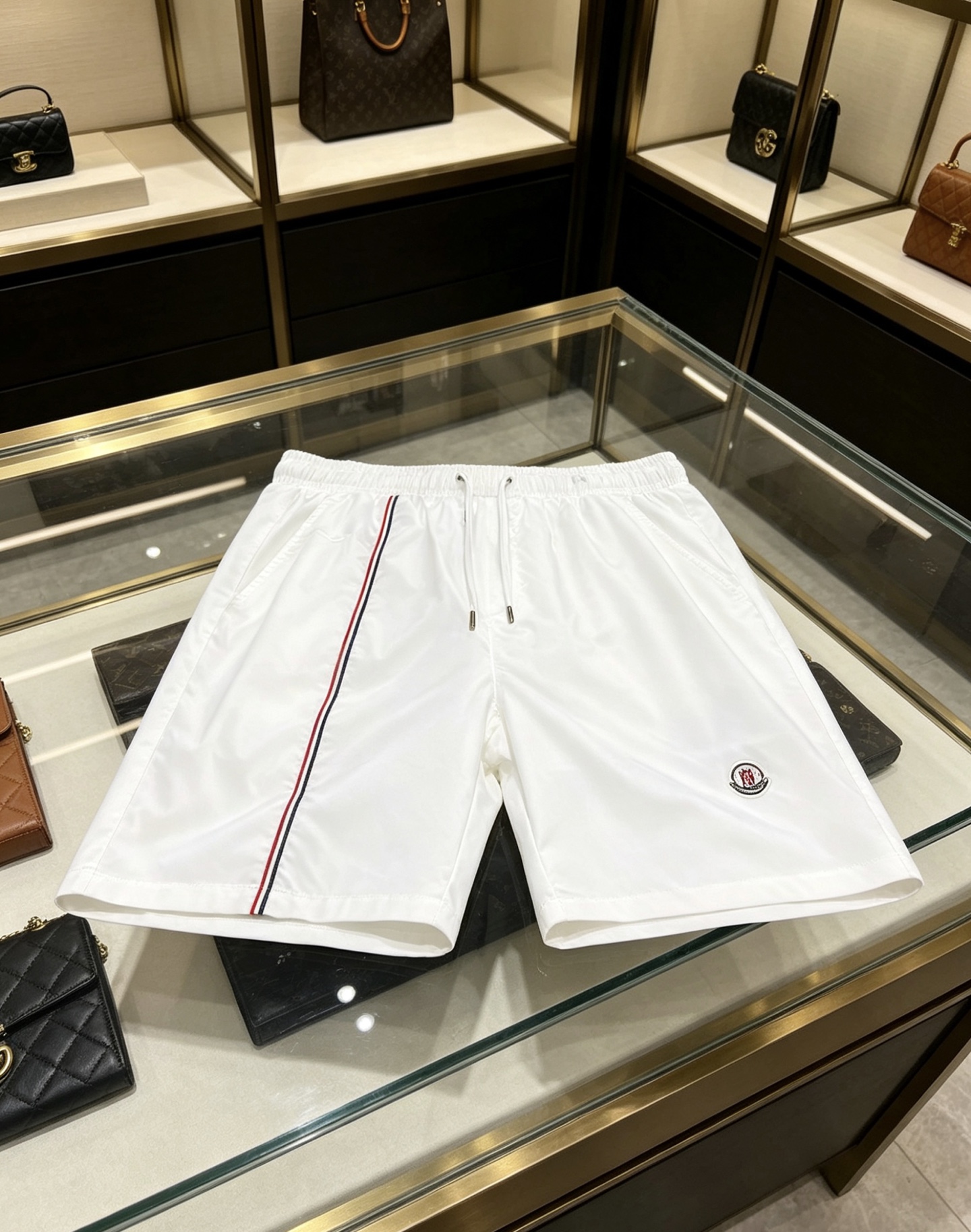 NO:847475,Moncler 2026ss men's summer classic web casual shorts, available in white/black colors. Made of high-density breathable nylon fabric, anti-wrinkle and easy to care for; the iconic three-color webbing and badge logo highlight the brand texture, multi-pocket design takes into account both practicality and style, elastic drawstring waistband with straight loose fit, easy to create a refreshing and high-end summer outfit. Size 48-56,,Moncler,shorts,19860909Moncler 蒙口 2026ss男士夏季经典织带休闲短裤,白/黑双色可选.采用高密透气尼龙面料,抗皱易打理；标志性三色织带与徽章标识彰显品牌质感,多口袋设计兼顾实用与造型,弹力抽绳腰头搭配直筒宽松版型,轻松打造夏日清爽高级穿搭. 码数48-56,,Moncler,shorts,,Men's clothing