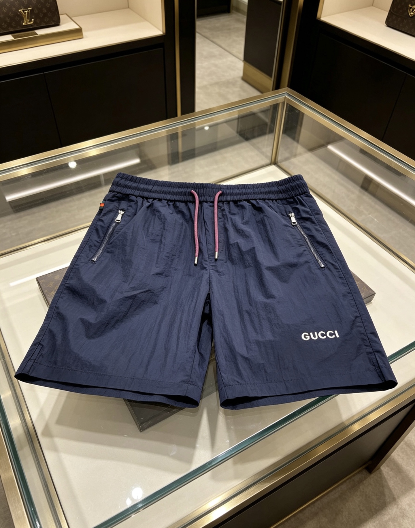 NO:931662,Gucci Gucci  The 2026ss summer limited edition contrasting color drawstring casual shorts cleverly combine the brand's classic webbing elements with refreshing functional style. They are available in navy blue/off-white and are suitable for a variety of summer styles. Made of high-density wrinkled nylon fabric, they are lightweight and breathable. The upper body is draped and stylish, without fear of stuffiness and wrinkles; the waistband is designed with a contrasting pink drawstring  Designed with classic red and green webbing details on the side, the brand genes can be recognized at a glance. The front zipper pocket is both practical and neat. The GUCCI letter logo on the front and the metal badge pocket on the back are low-key. The loose straight version modifies the leg shape. Whether you are commuting in the city or traveling on vacation, you can easily create a relaxed and noble summer style.  Color: navy blue, off-white, size 48-56,,gucci,shorts,19860909Gucci 古奇 2026ss夏季限定撞色抽绳休闲短裤,将品牌经典织带元素与清爽机能风巧妙融合,藏青/米白双色可选,适配多元夏日风格.甄选高密皱感尼龙面料打造,自带轻量透气属性,上身垂坠有型,无惧闷热与褶皱；腰头撞色粉调抽绳设计,搭配侧边经典红绿织带细节,一眼识别品牌基因.前侧拉链口袋兼顾实用与利落,正面GUCCI字母标识与背面金属徽章口袋低调点题,宽松直筒版型修饰腿型,无论是都市通勤还是度假出行,都能轻松塑造松弛显贵的夏日格调. 颜色藏青 米白 码数48-56,,gucci,shorts,,Men's clothing