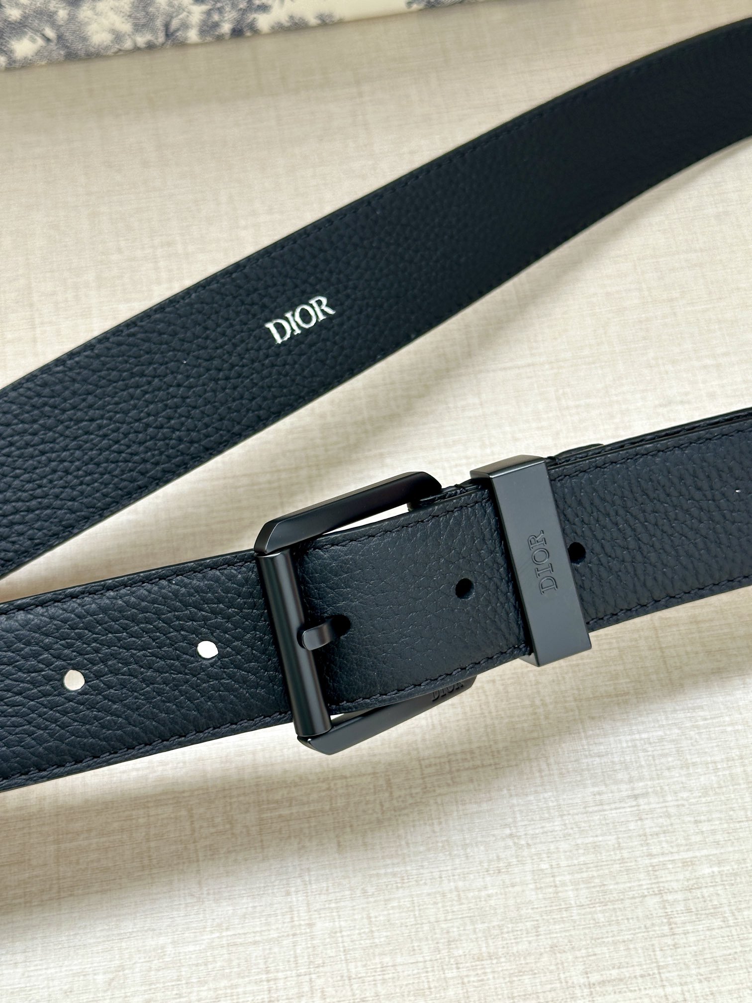 Dior 迪奥 宽度3 5cm Dior这款腰带采用黑色粒面牛皮革精心制作 搭配金属覆层黄铜腰带扣和镌刻“DIOR”标志的调节环