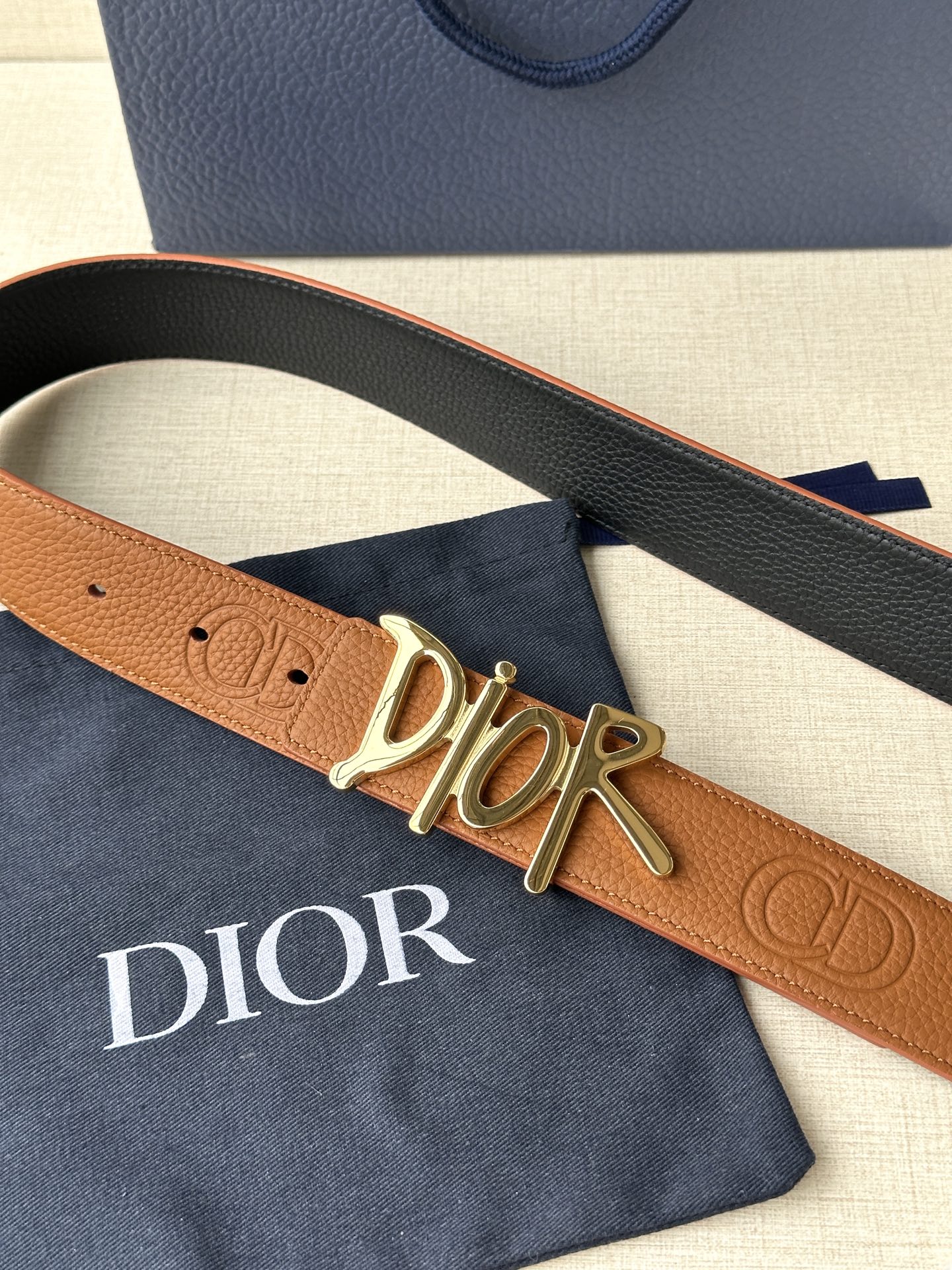  Dior 这款双面腰带结合典雅气质与摩登风范。双面均采用粒面牛皮革精心制作，一面为黑色，另一面多色可选
