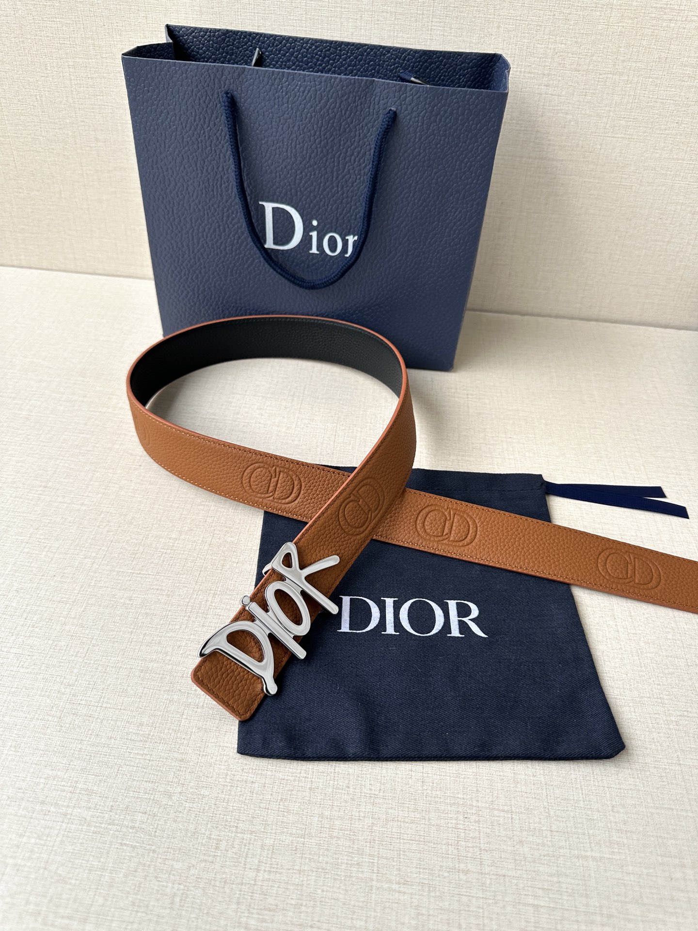  Dior 这款双面腰带结合典雅气质与摩登风范。双面均采用粒面牛皮革精心制作，一面为黑色，另一面多色可选