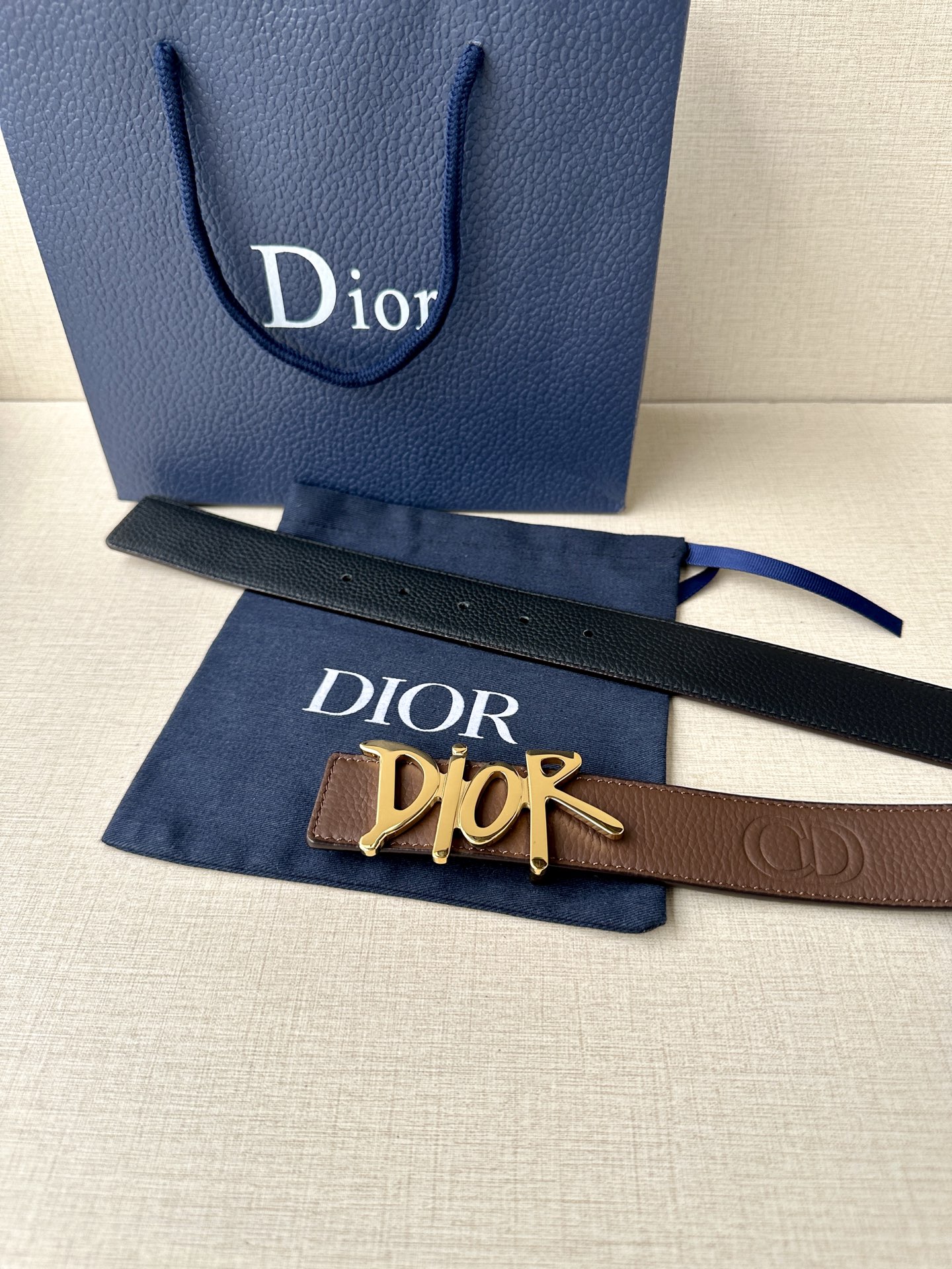  Dior 这款双面腰带结合典雅气质与摩登风范。双面均采用粒面牛皮革精心制作，一面为黑色，另一面多色可选