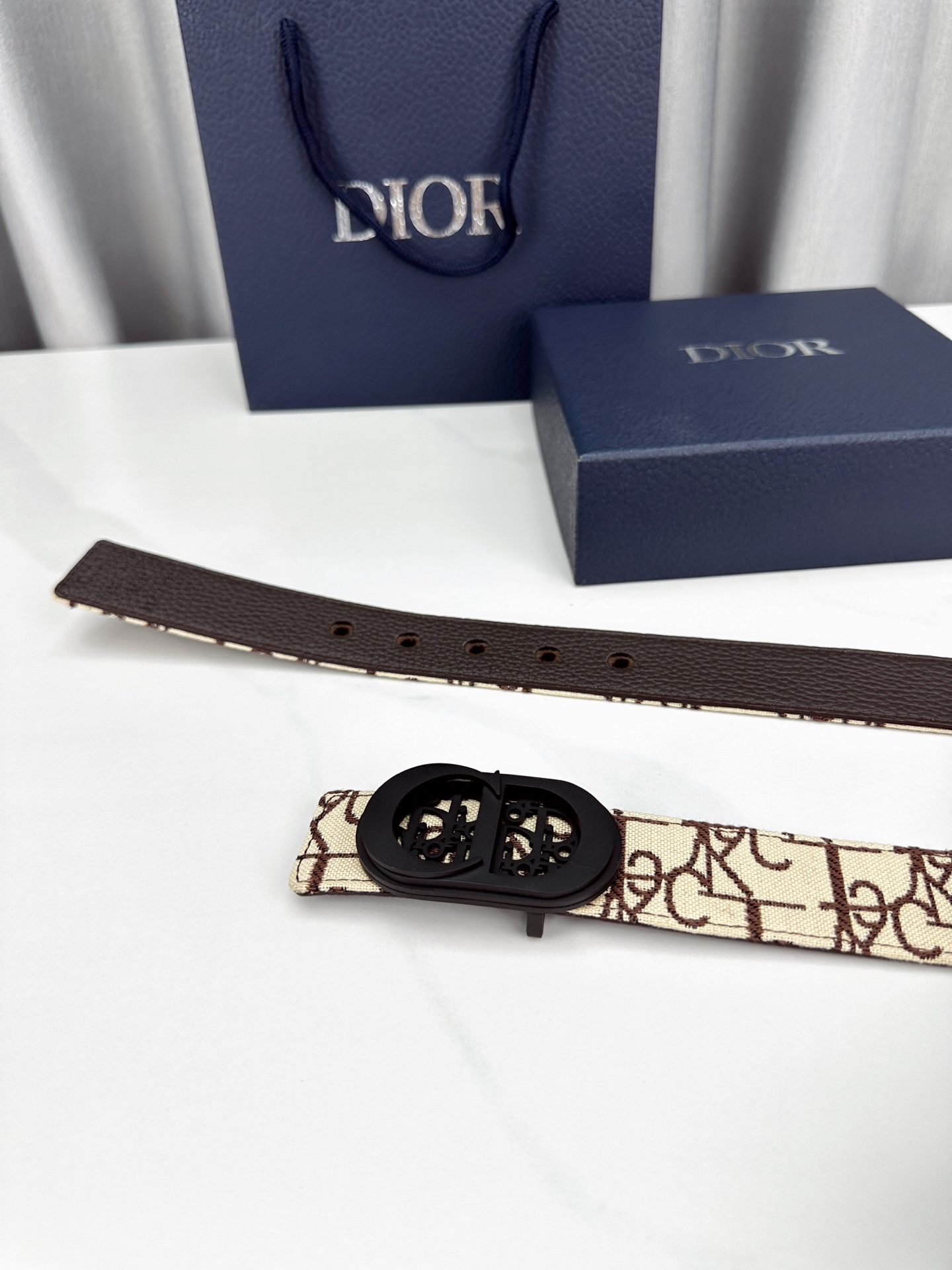 宽度3.5cm 这款腰带扣以 Oblique Cosmo 图案金属饰牌诠释品牌经典图案，以金色/白色饰面