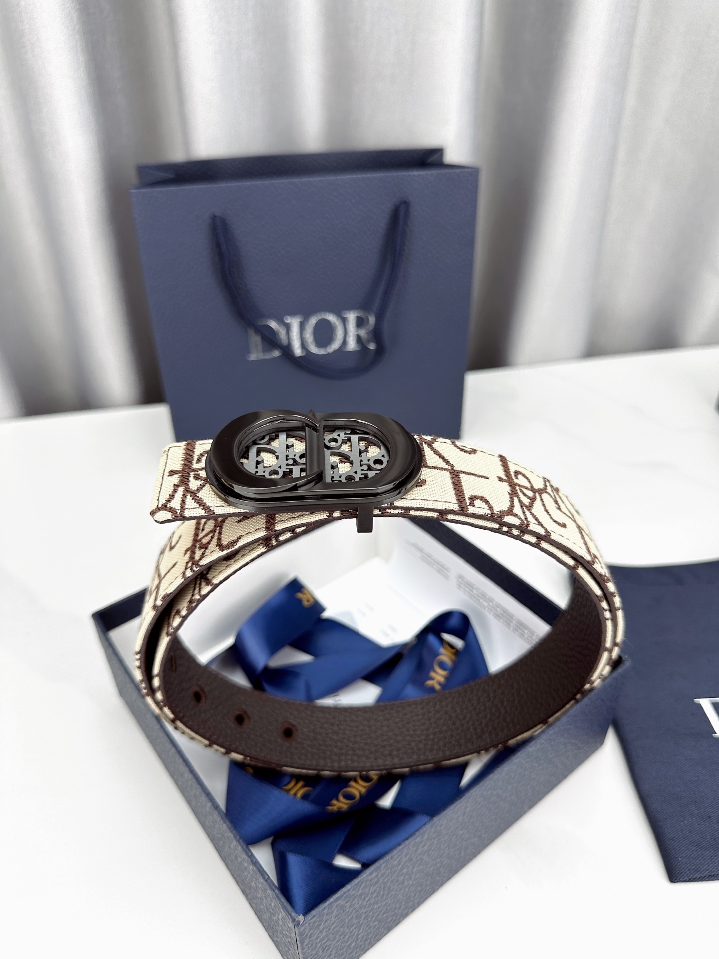 宽度3.5cm 这款腰带扣以 Oblique Cosmo 图案金属饰牌诠释品牌经典图案，以金色/白色饰面