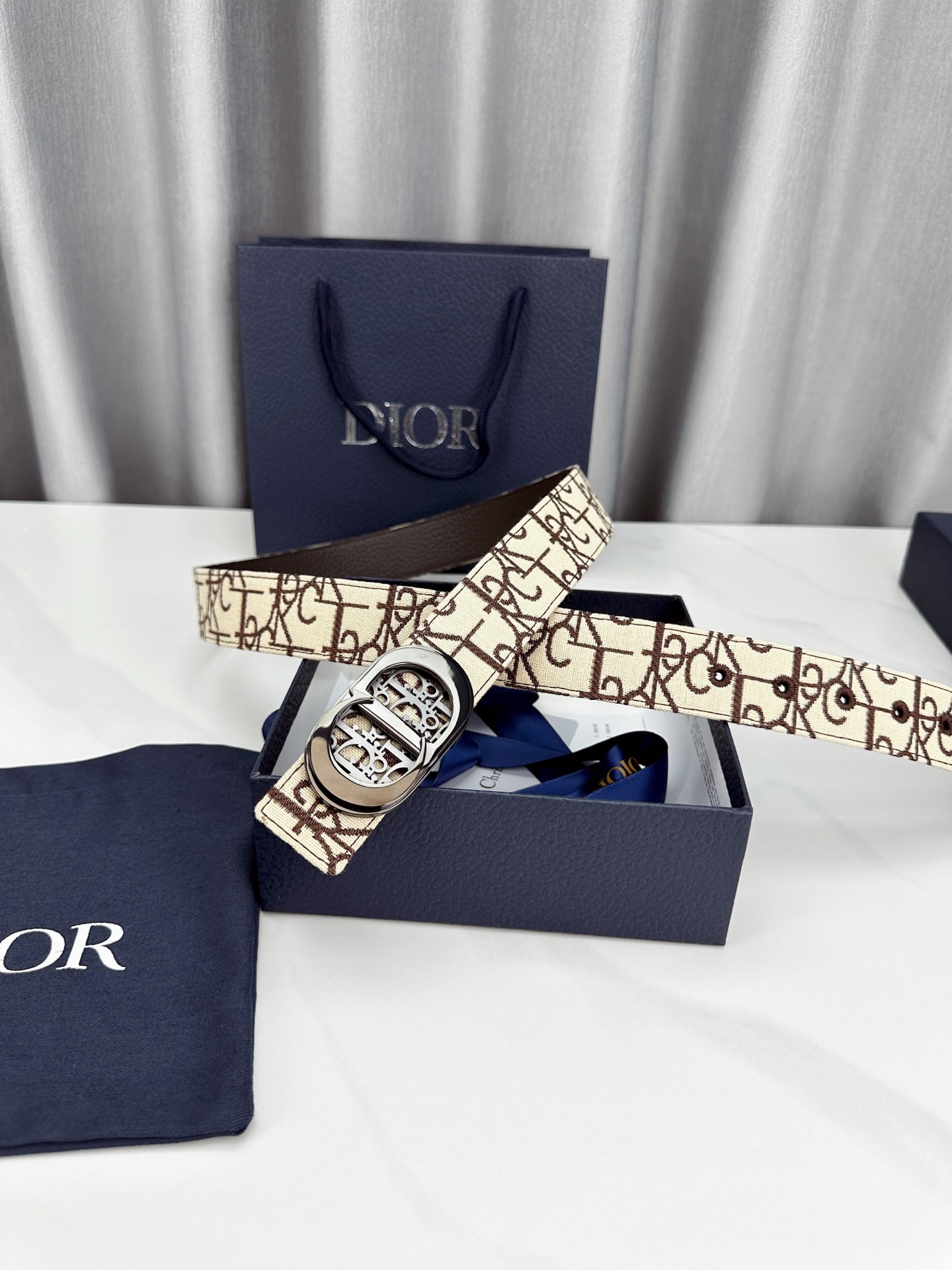 宽度3.5cm 这款腰带扣以 Oblique Cosmo 图案金属饰牌诠释品牌经典图案，以金色/白色饰面