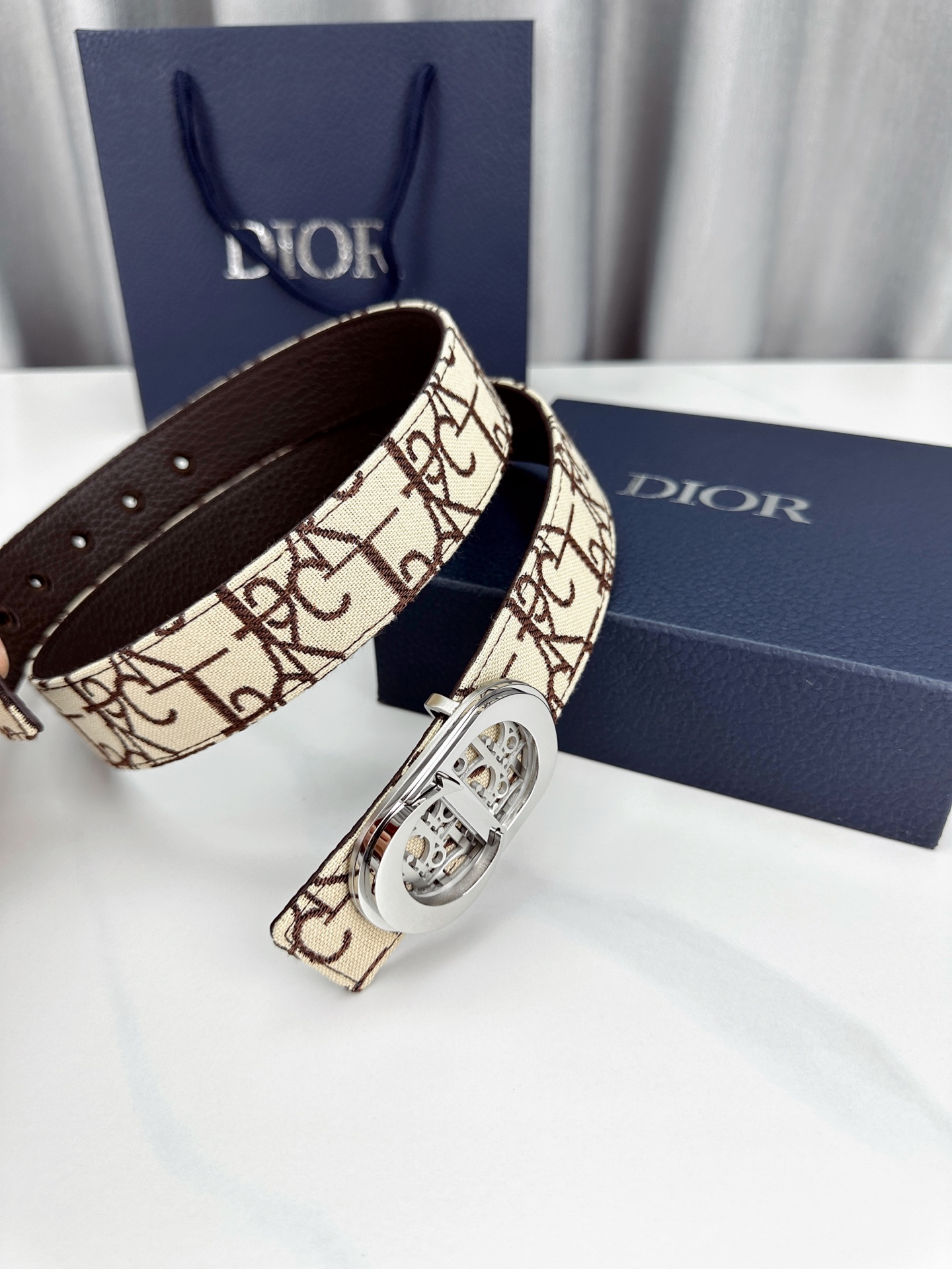 宽度3.5cm 这款腰带扣以 Oblique Cosmo 图案金属饰牌诠释品牌经典图案，以金色/白色饰面