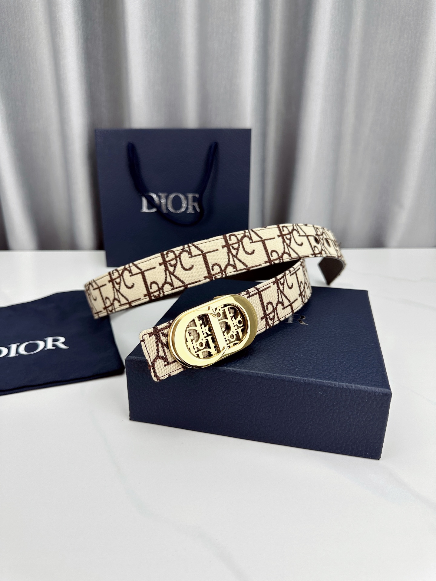 宽度3.5cm 这款腰带扣以 Oblique Cosmo 图案金属饰牌诠释品牌经典图案，以金色/白色饰面