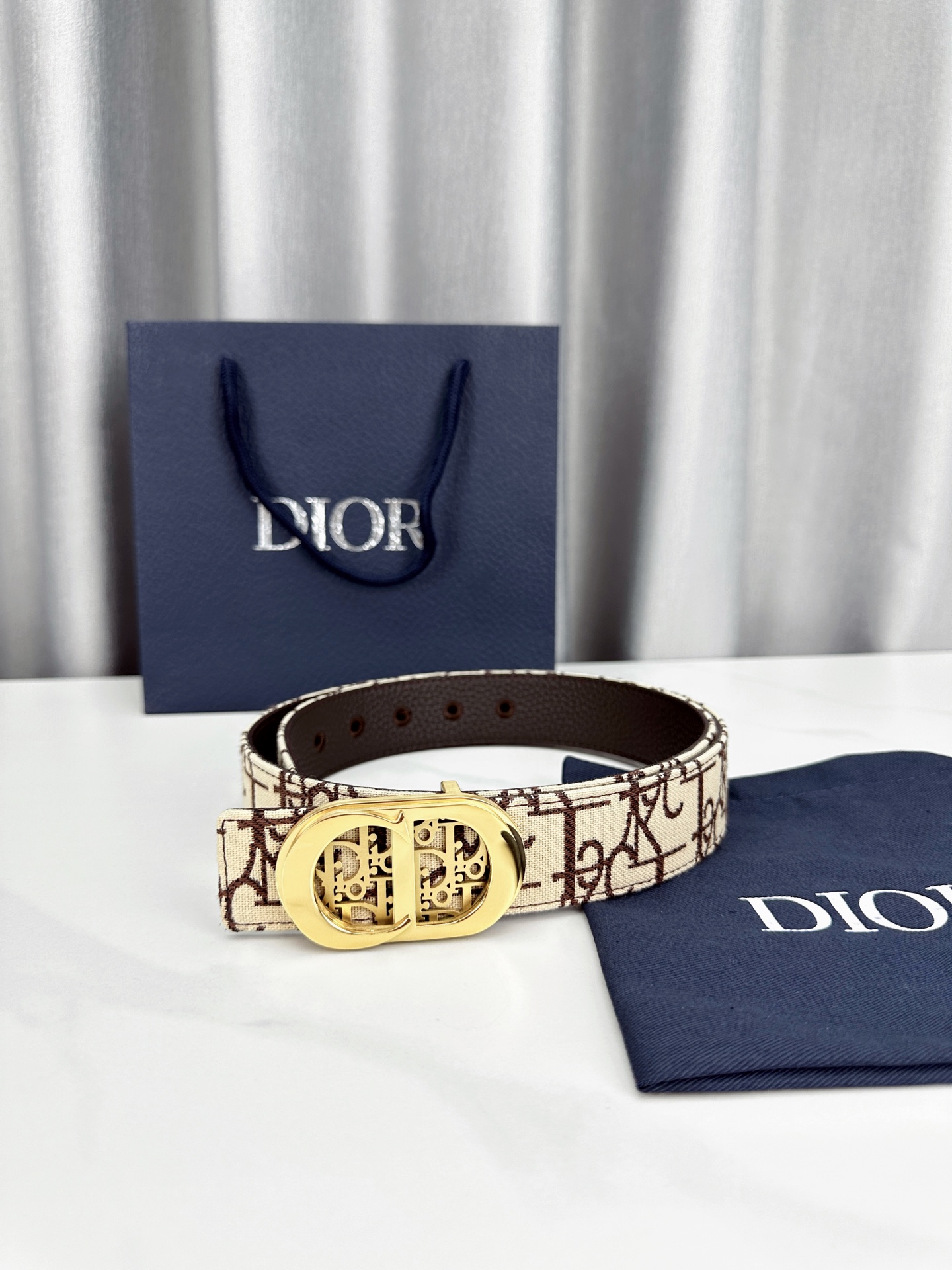 宽度3.5cm 这款腰带扣以 Oblique Cosmo 图案金属饰牌诠释品牌经典图案，以金色/白色饰面