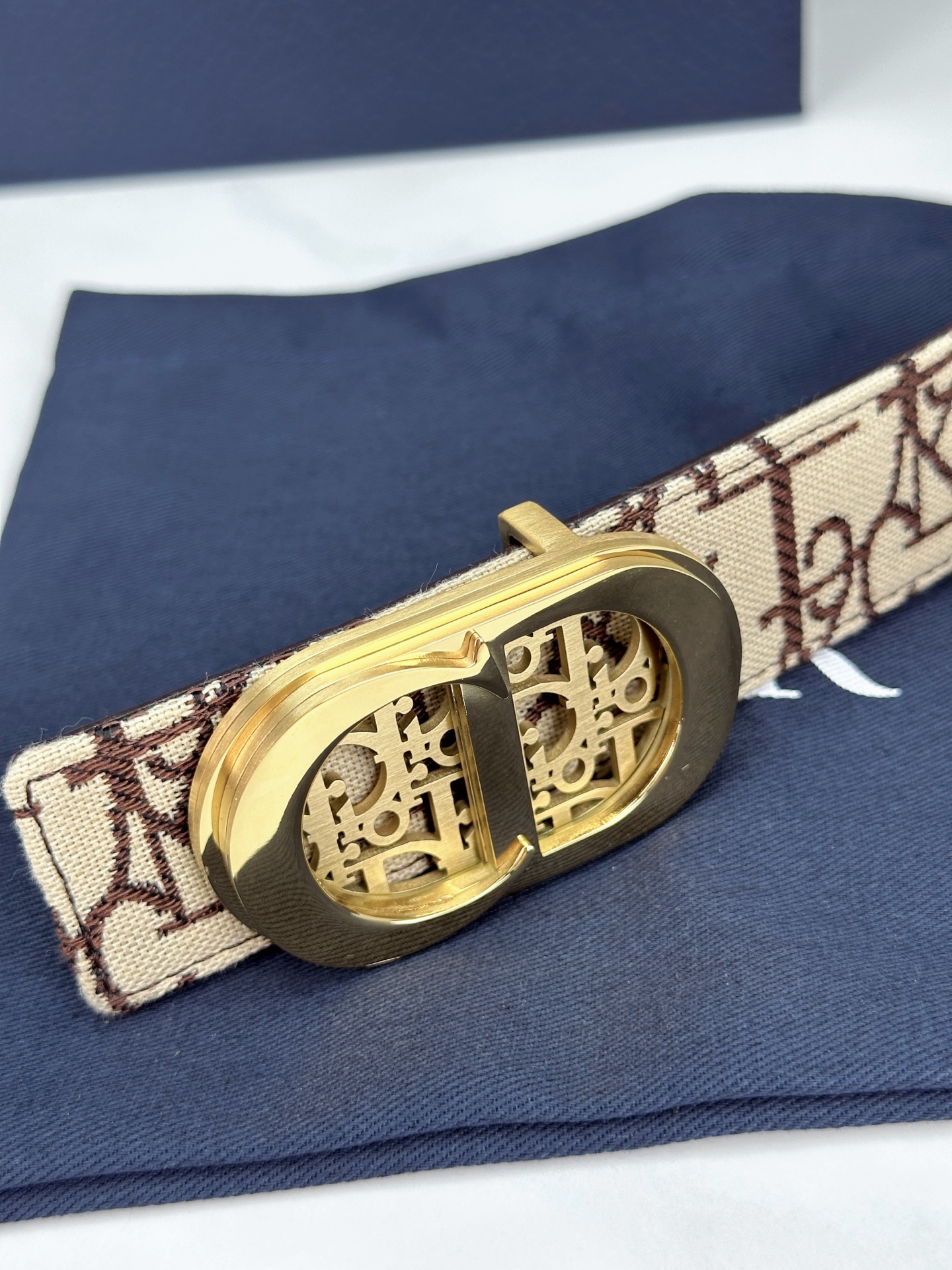 宽度3.5cm 这款腰带扣以 Oblique Cosmo 图案金属饰牌诠释品牌经典图案，以金色/白色饰面