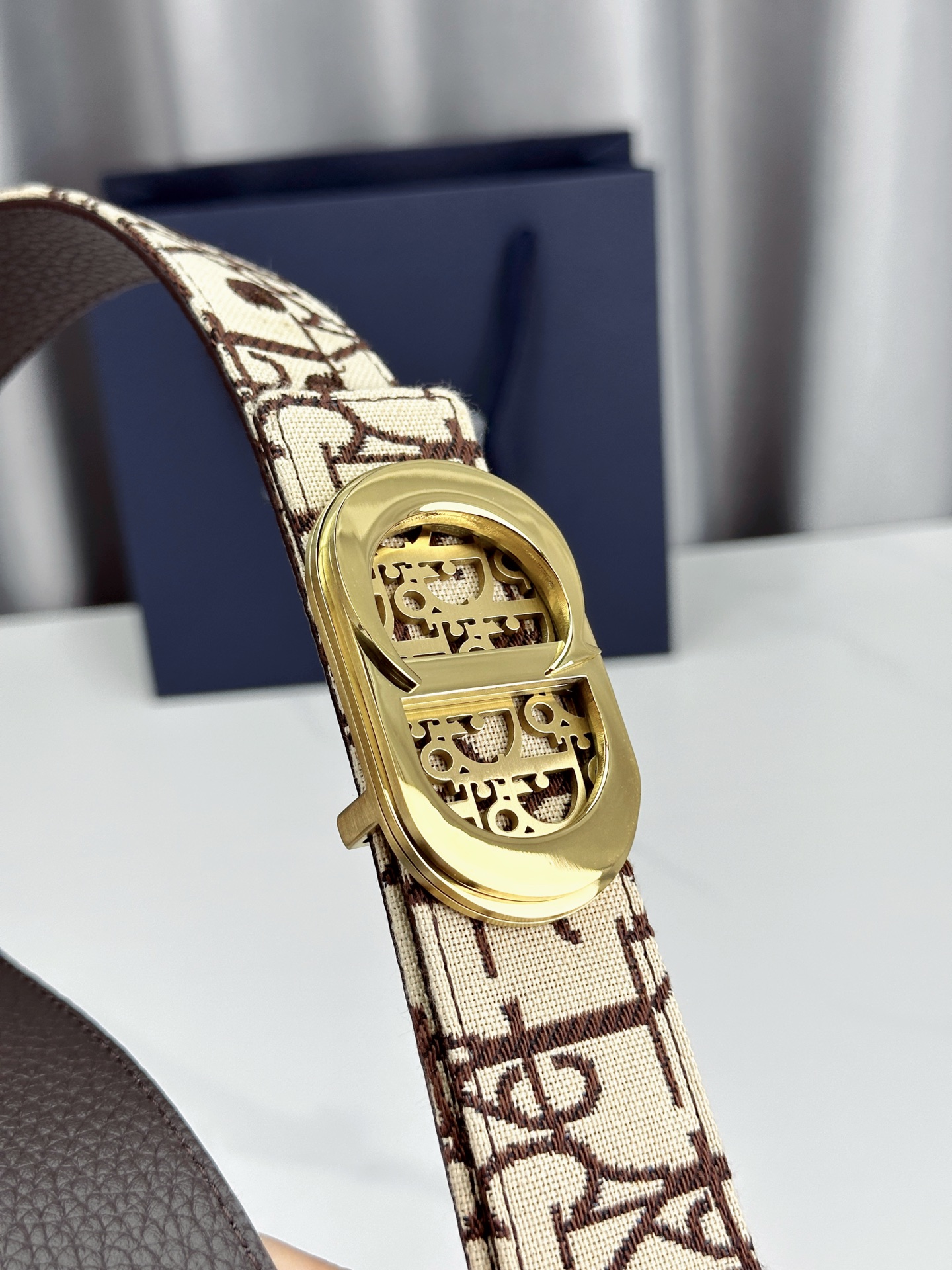 宽度3.5cm 这款腰带扣以 Oblique Cosmo 图案金属饰牌诠释品牌经典图案，以金色/白色饰面