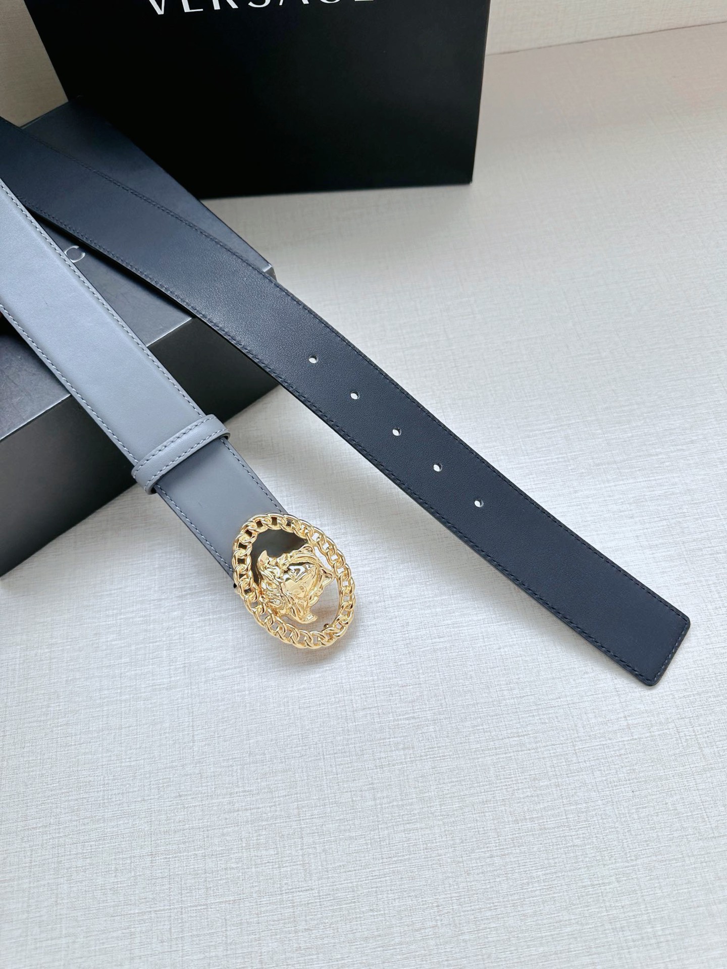 宽度4.0cm 范思哲这款荔枝纹柔软头层皮饰带搭配一枚椭圆型美杜莎带扣。本季标志性的Versace饰件点