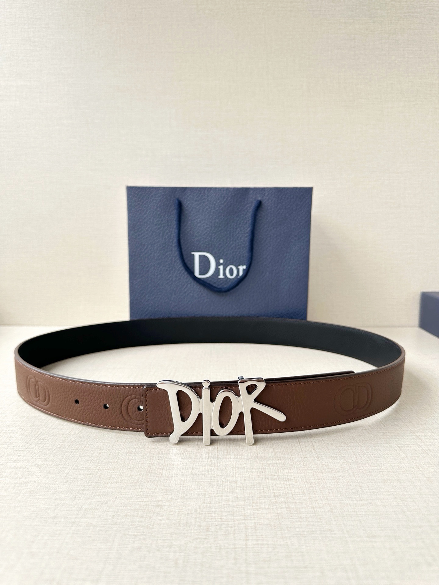 Dior 这款双面腰带结合典雅气质与摩登风范。双面均采用粒面牛皮革精心制作，一面为黑色，另一面多色可选 