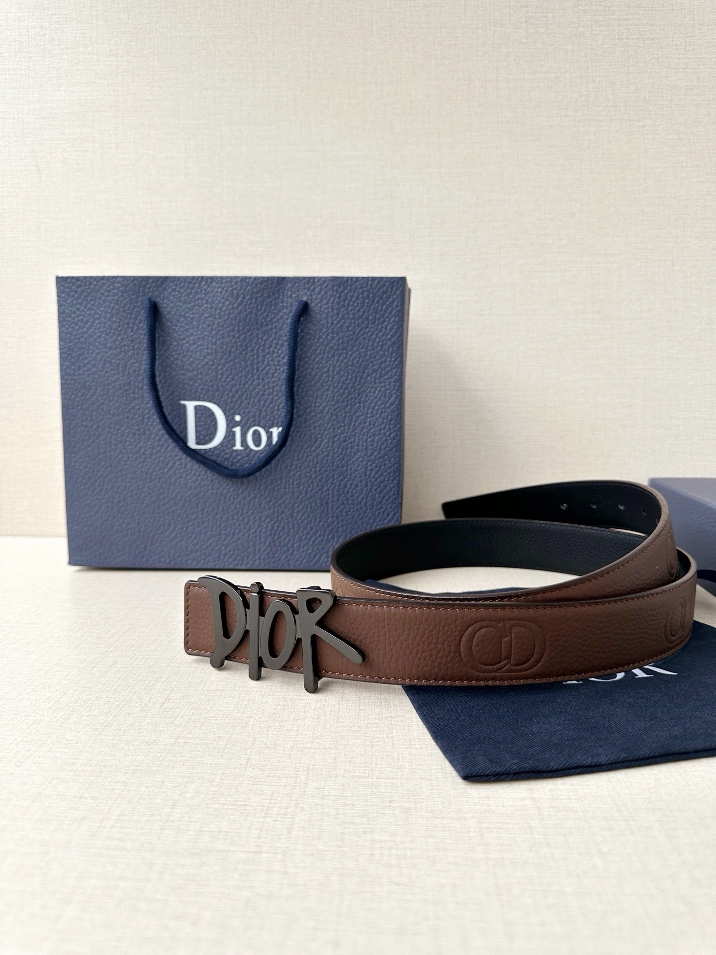 Dior 这款双面腰带结合典雅气质与摩登风范。双面均采用粒面牛皮革精心制作，一面为黑色，另一面多色可选 