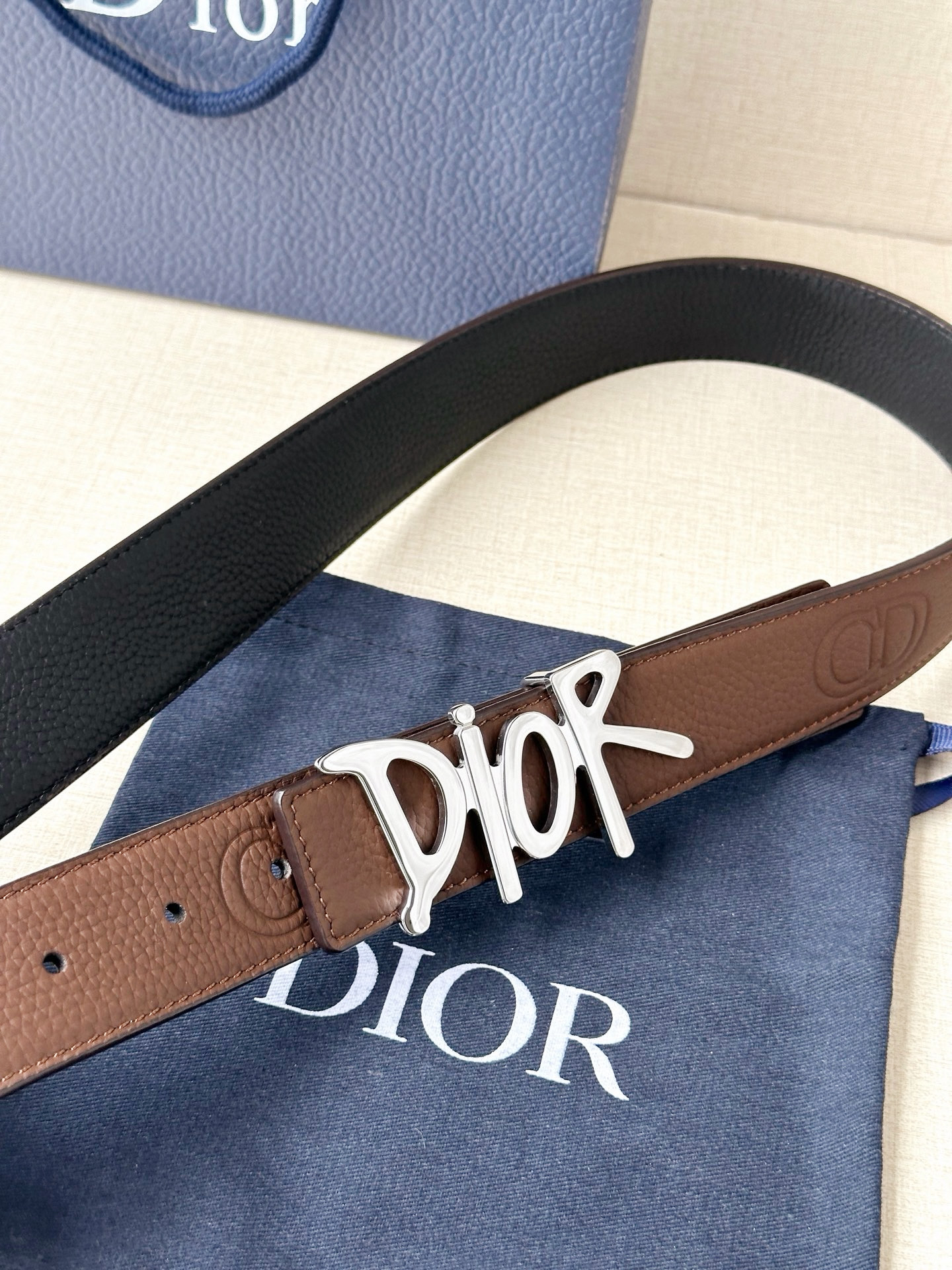 Dior 这款双面腰带结合典雅气质与摩登风范。双面均采用粒面牛皮革精心制作，一面为黑色，另一面多色可选 