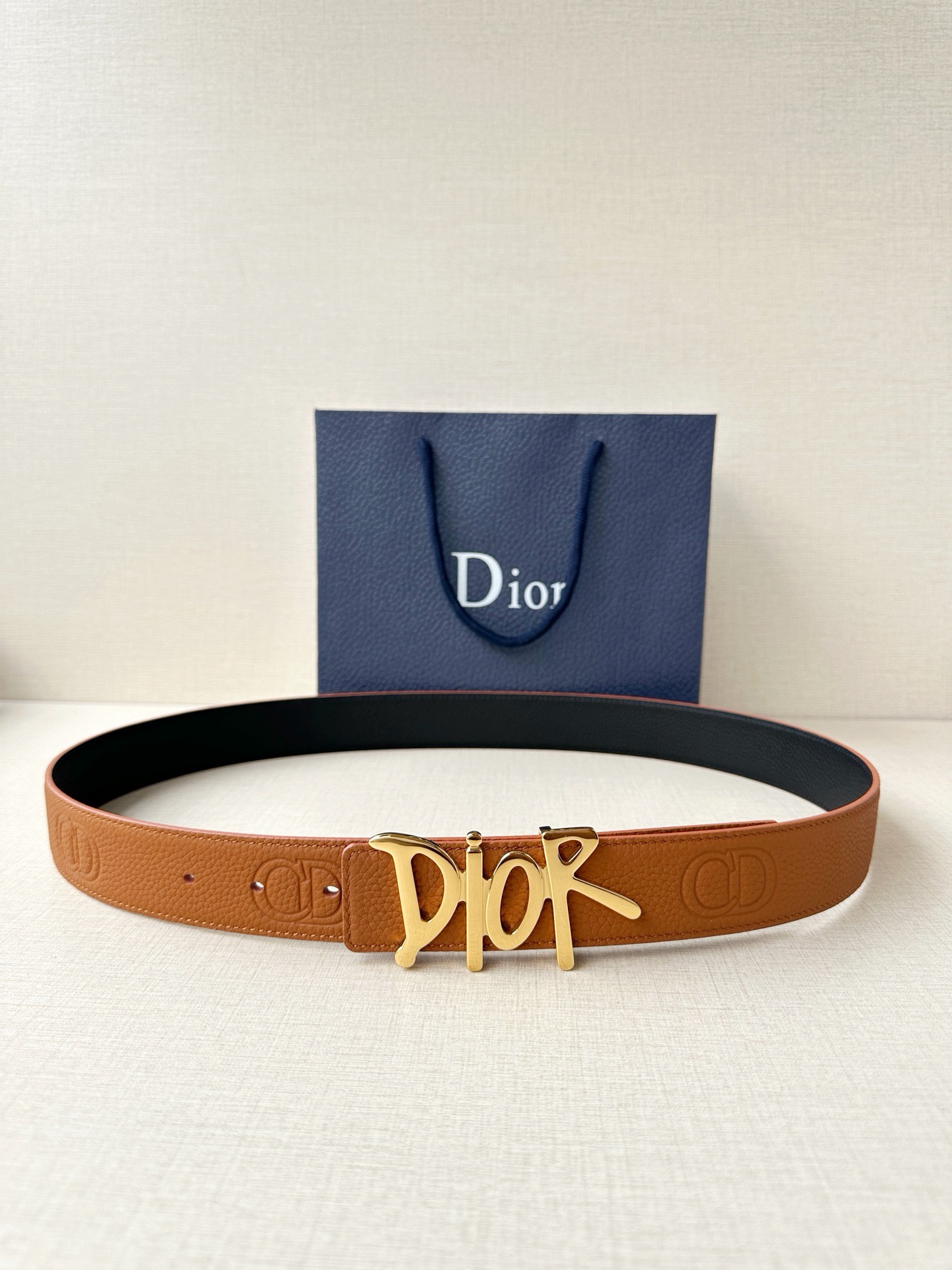Dior 这款双面腰带结合典雅气质与摩登风范。双面均采用粒面牛皮革精心制作，一面为黑色，另一面多色可选 
