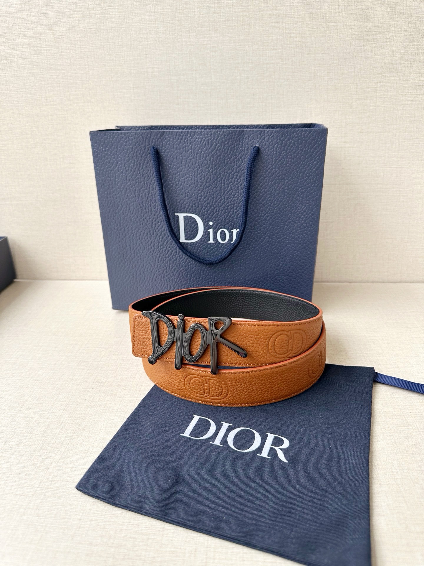 Dior 这款双面腰带结合典雅气质与摩登风范。双面均采用粒面牛皮革精心制作，一面为黑色，另一面多色可选 