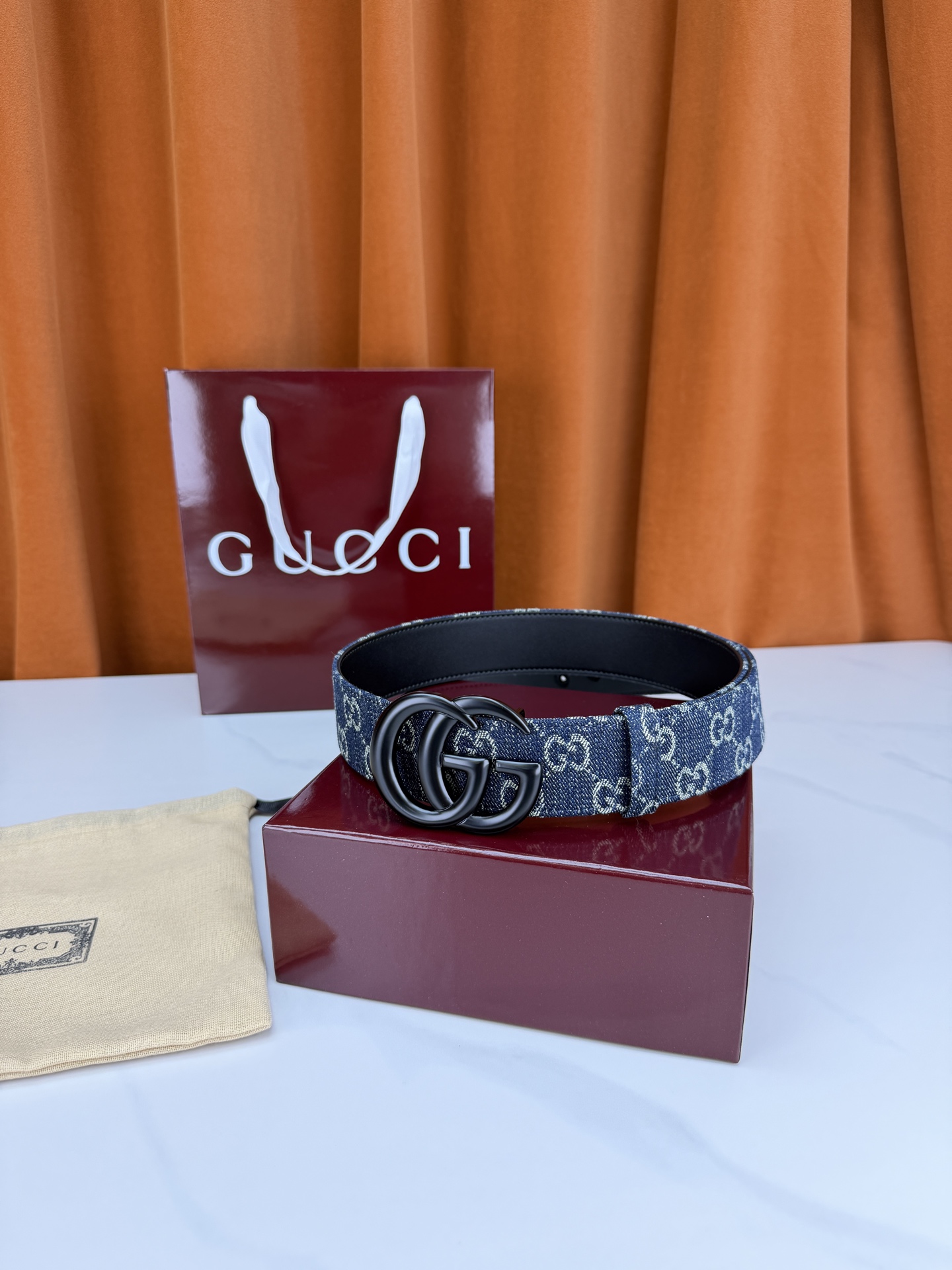 GUCCI 4.0cm宽度老花帆布腰带，深蓝底色织满GG经典提花，反面黑色光面皮革双面从容。立体双G金属