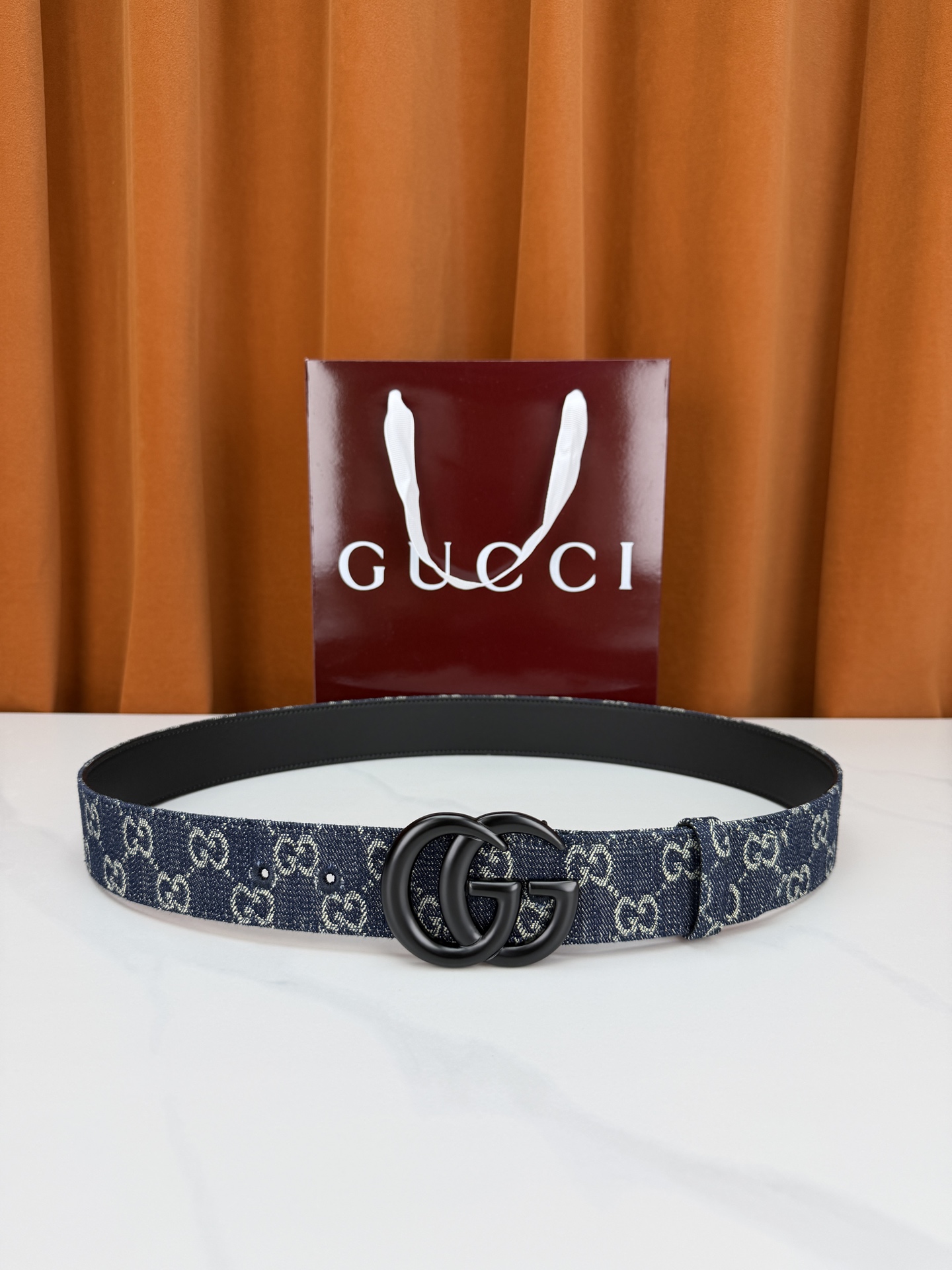 GUCCI 4.0cm宽度老花帆布腰带，深蓝底色织满GG经典提花，反面黑色光面皮革双面从容。立体双G金属