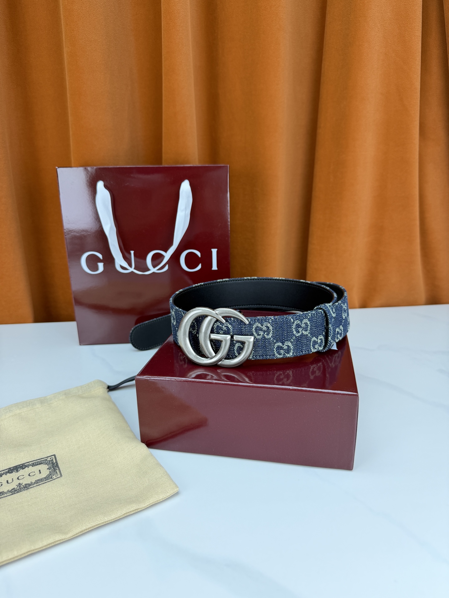 GUCCI 4.0cm宽度老花帆布腰带，深蓝底色织满GG经典提花，反面黑色光面皮革双面从容。立体双G金属