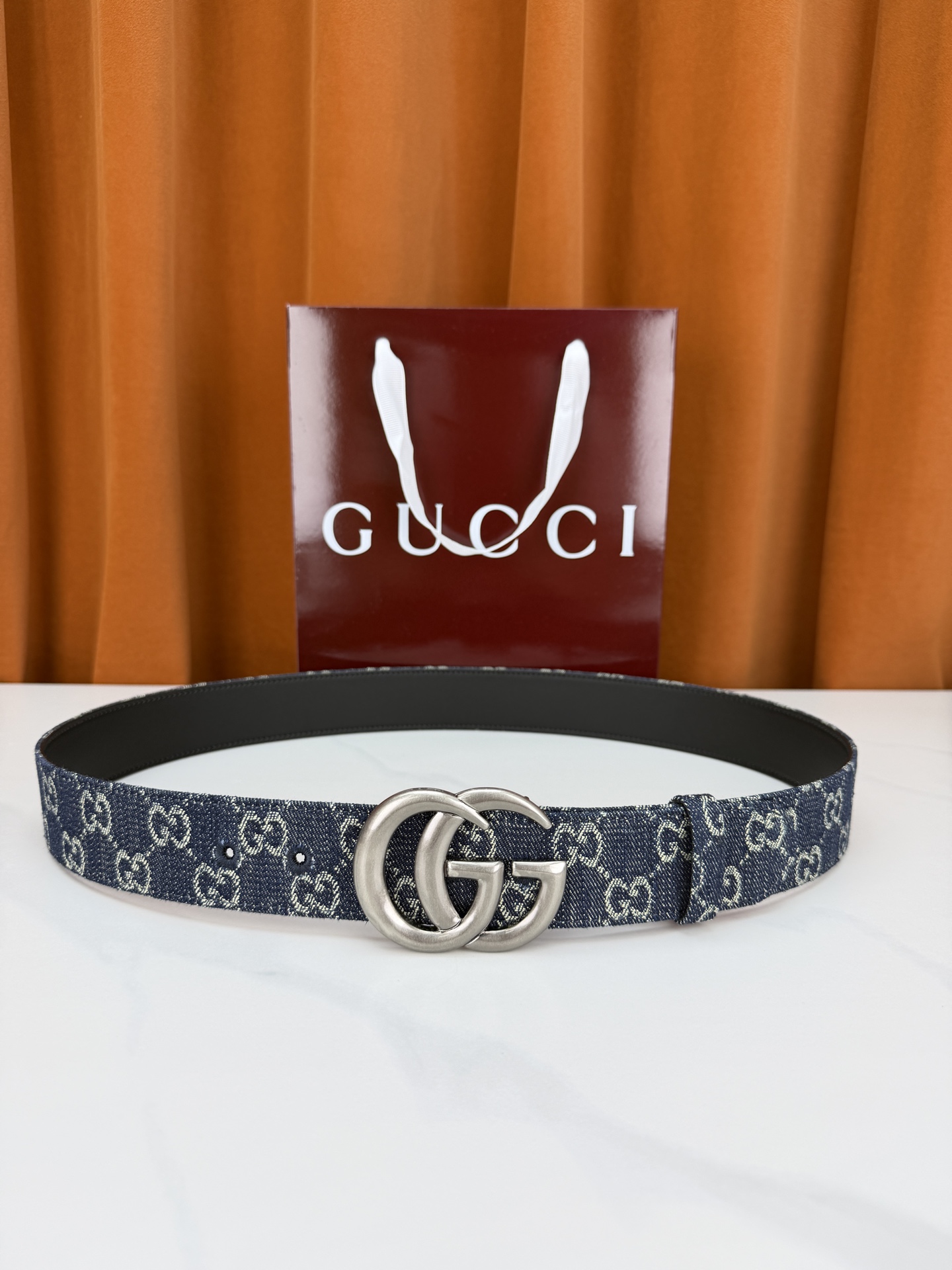 GUCCI 4.0cm宽度老花帆布腰带，深蓝底色织满GG经典提花，反面黑色光面皮革双面从容。立体双G金属