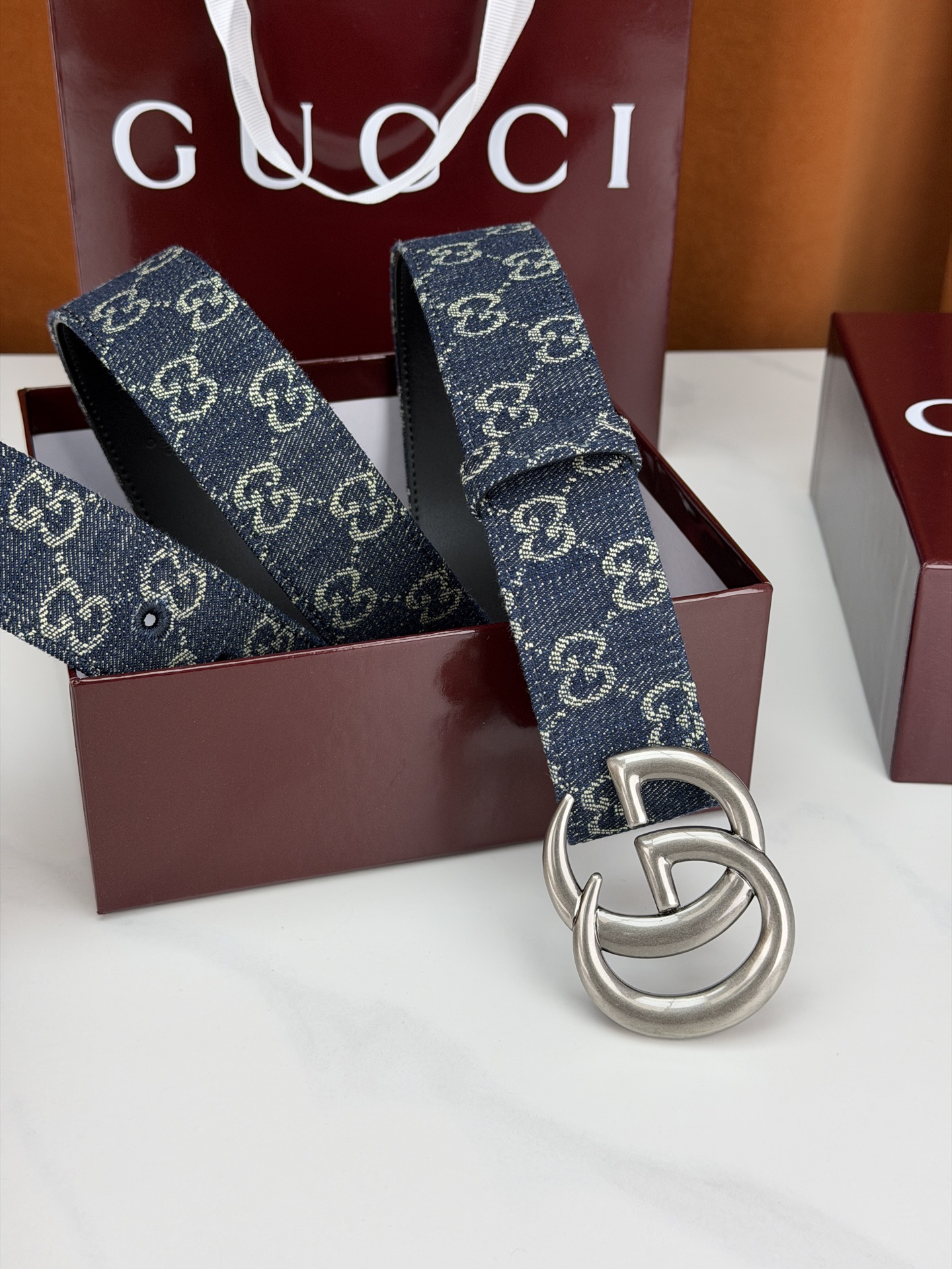 GUCCI 4.0cm宽度老花帆布腰带，深蓝底色织满GG经典提花，反面黑色光面皮革双面从容。立体双G金属