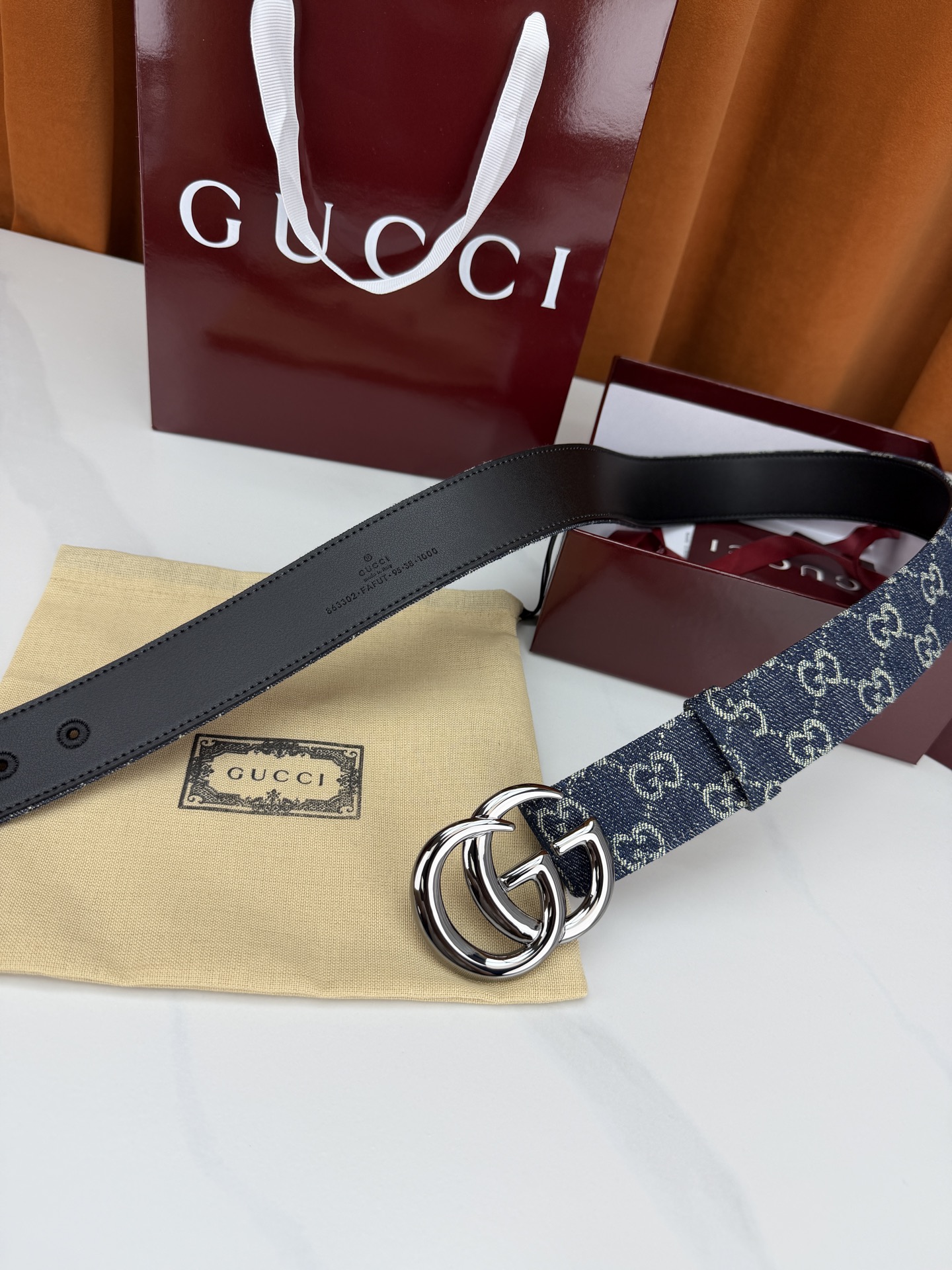 GUCCI 4.0cm宽度老花帆布腰带，深蓝底色织满GG经典提花，反面黑色光面皮革双面从容。立体双G金属