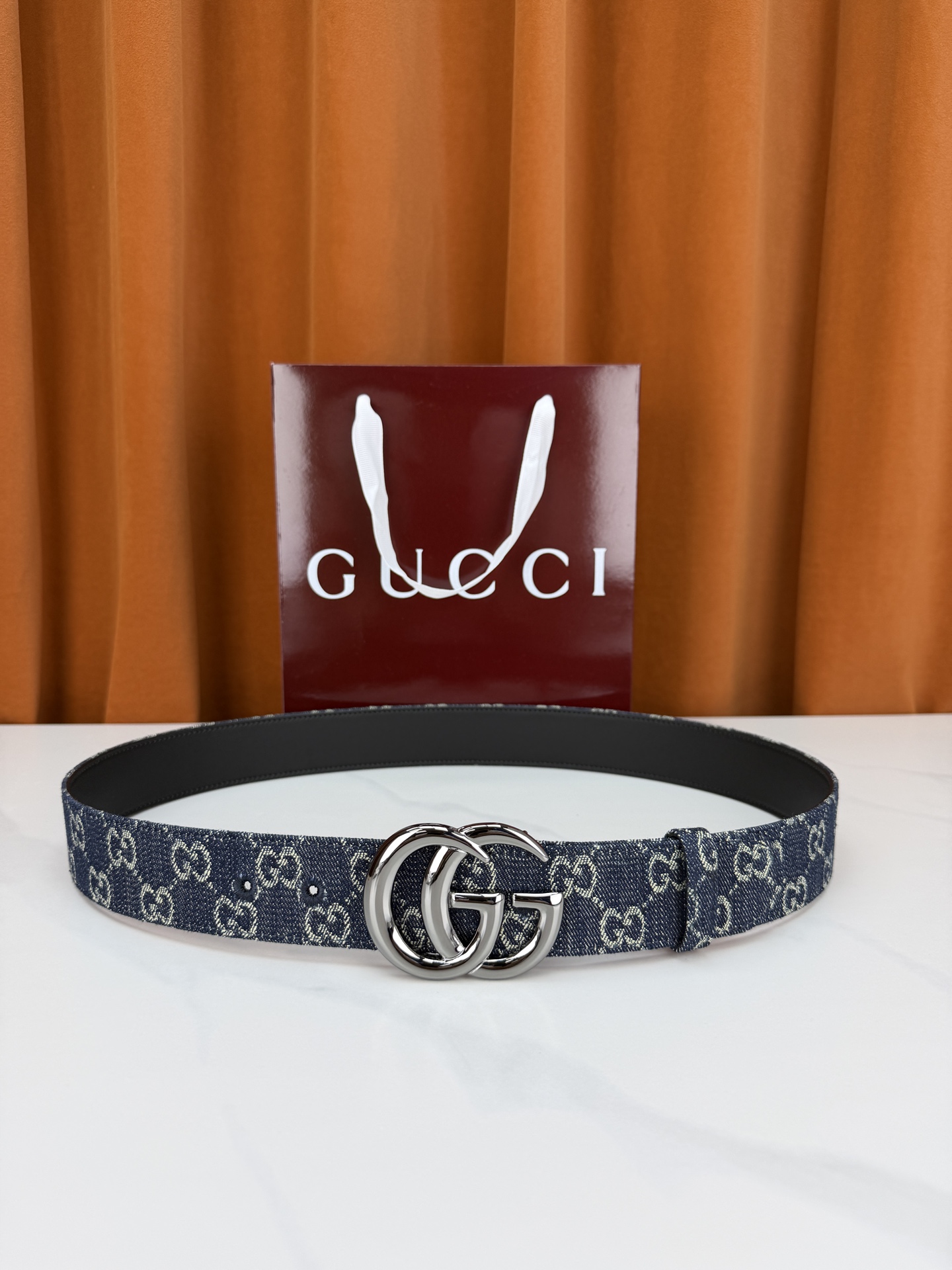 GUCCI 4.0cm宽度老花帆布腰带，深蓝底色织满GG经典提花，反面黑色光面皮革双面从容。立体双G金属