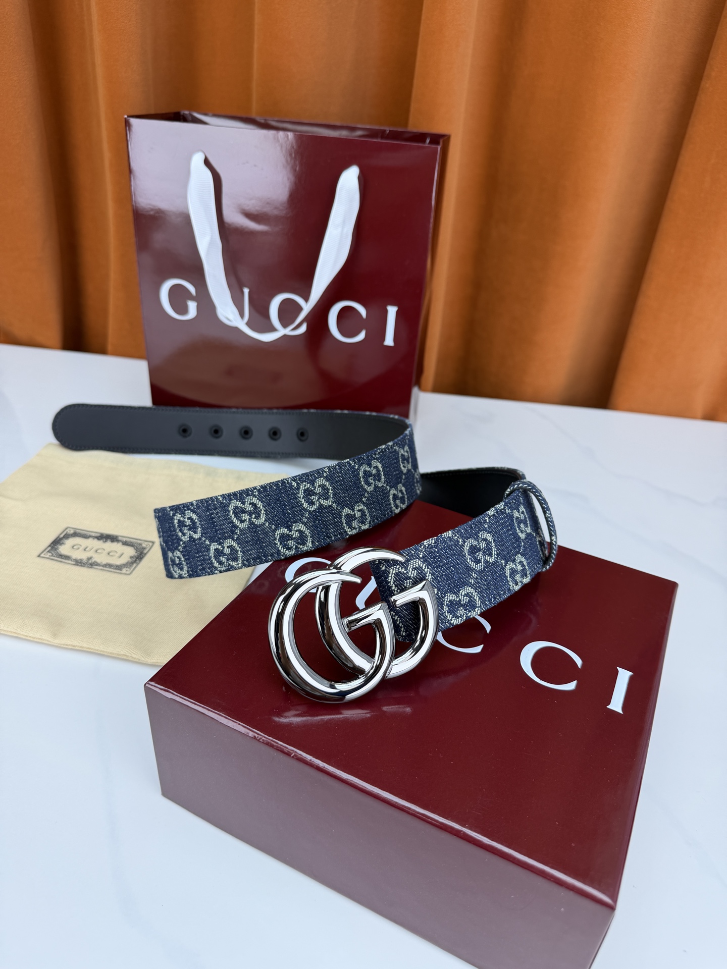 GUCCI 4.0cm宽度老花帆布腰带，深蓝底色织满GG经典提花，反面黑色光面皮革双面从容。立体双G金属