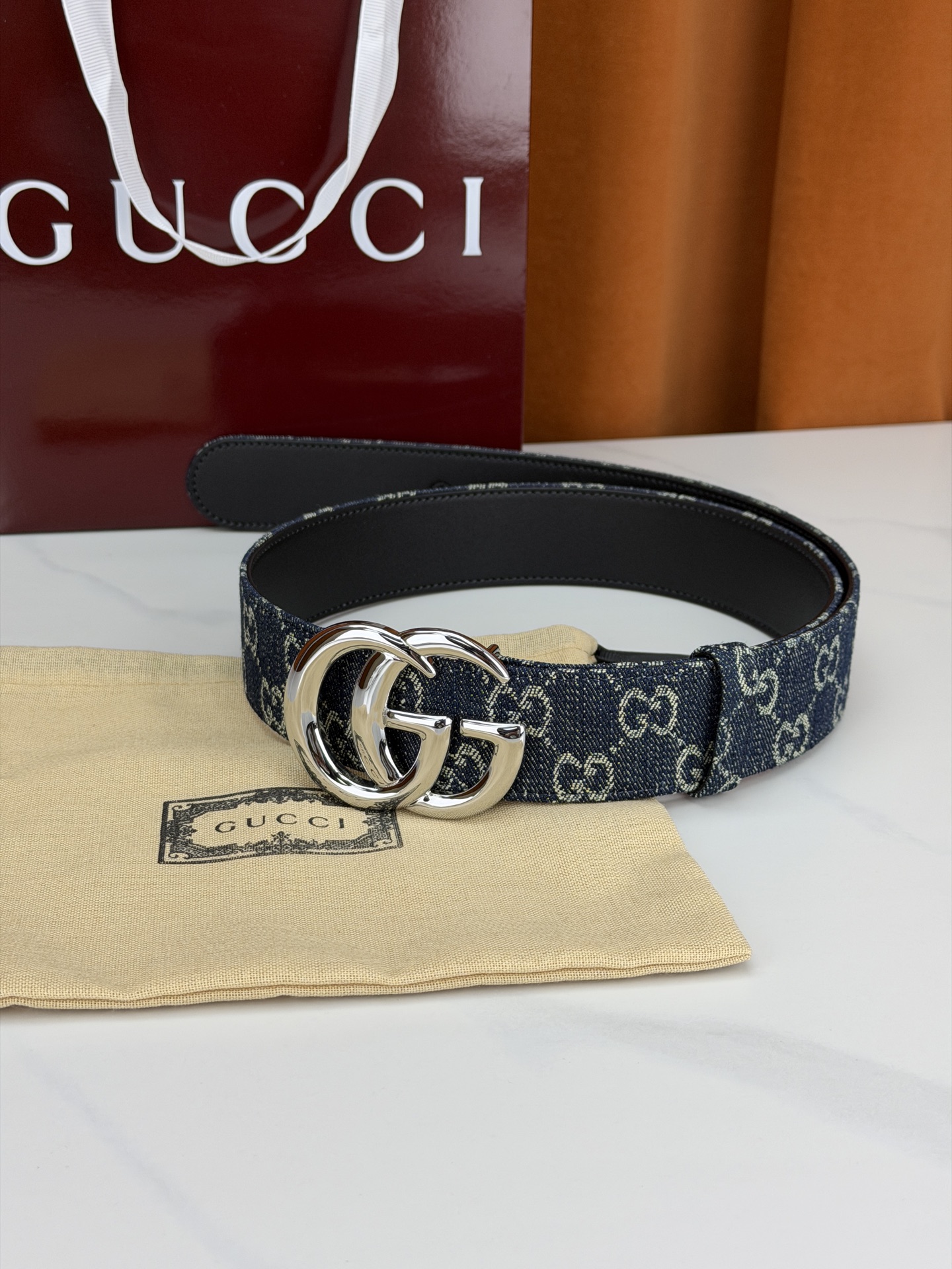 GUCCI 4.0cm宽度老花帆布腰带，深蓝底色织满GG经典提花，反面黑色光面皮革双面从容。立体双G金属