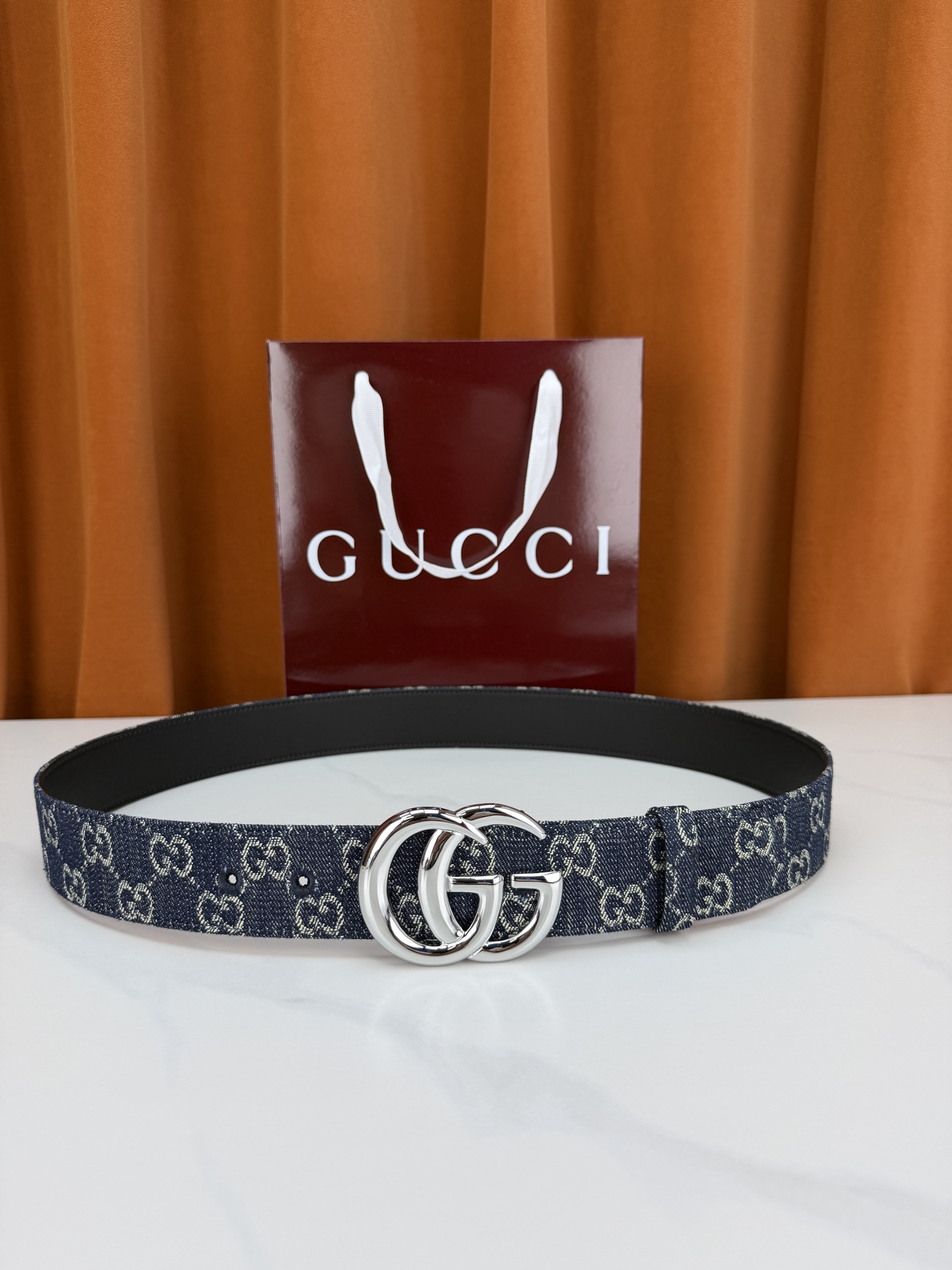 GUCCI 4.0cm宽度老花帆布腰带，深蓝底色织满GG经典提花，反面黑色光面皮革双面从容。立体双G金属