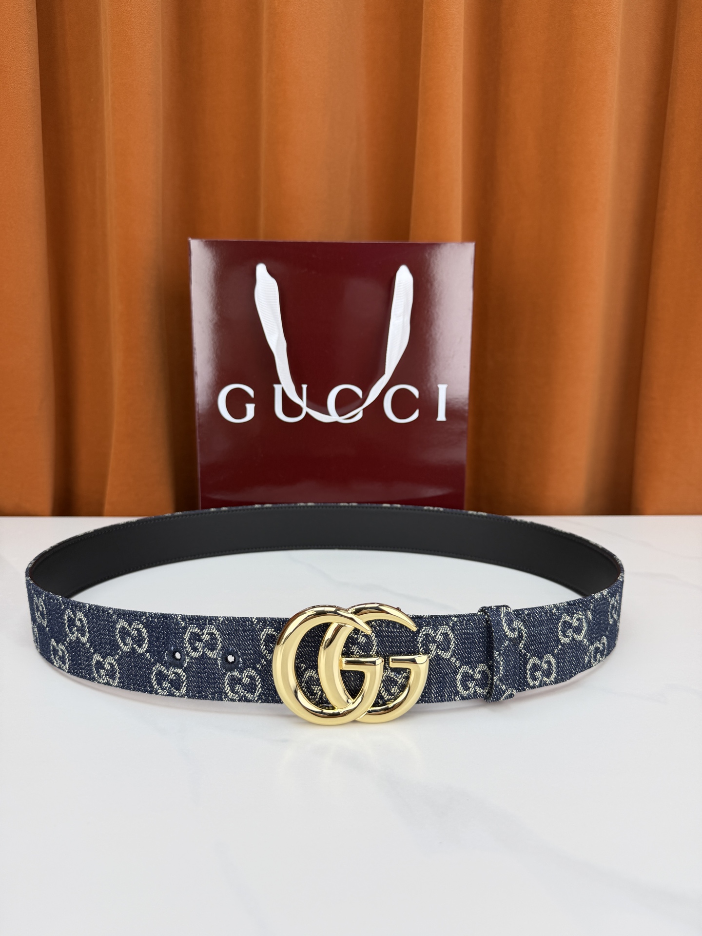 GUCCI 4.0cm宽度老花帆布腰带，深蓝底色织满GG经典提花，反面黑色光面皮革双面从容。立体双G金属