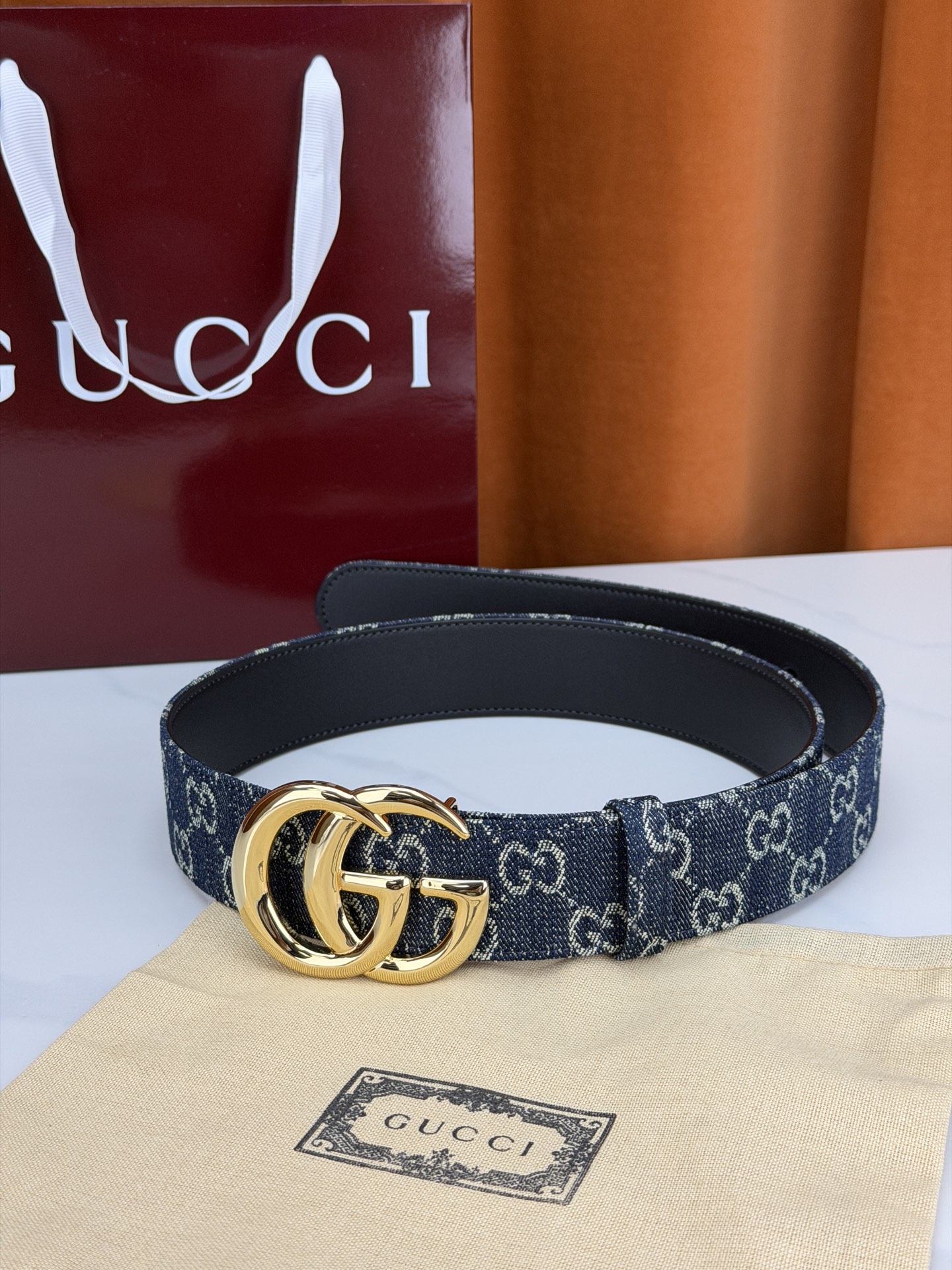 GUCCI 4.0cm宽度老花帆布腰带，深蓝底色织满GG经典提花，反面黑色光面皮革双面从容。立体双G金属