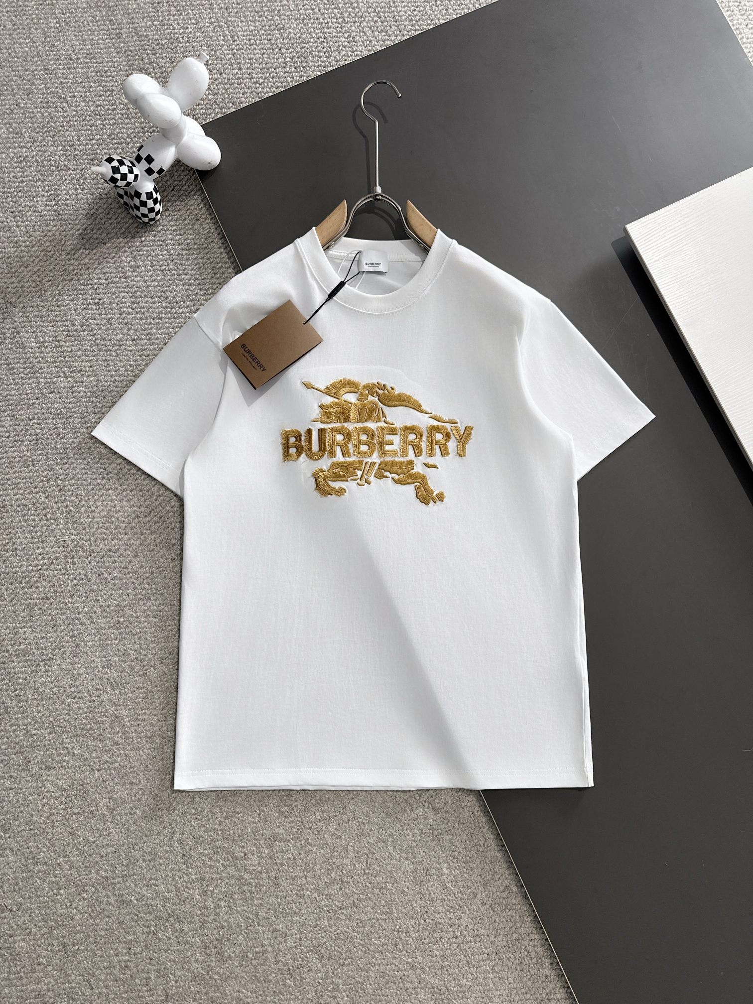 Burberry\n꯭0꯭꯭春夏款上新  P\n原高版本 \n巴宝莉 面料采用ZL克高密度纯棉 不变形 不缩水 \n工艺介绍：双线走位 胸前采用进口精密战马流苏刺绣新工艺\n颜色：白色\nSIZE：S-XXL