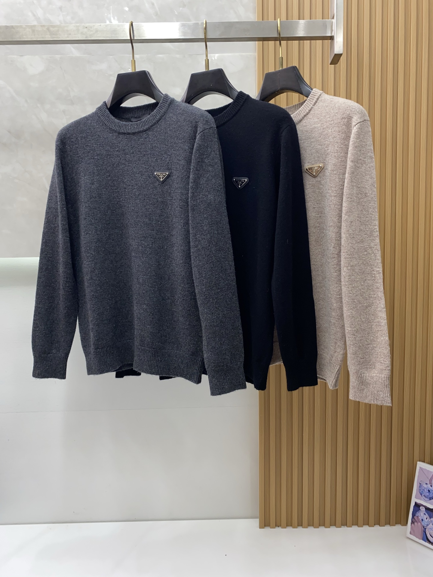 NO:595659,Prada's round-neck woolen sweater is woven with delicate fibers to convey the charm of time, telling timeless elegance in every stitch. In the field of men's high-end knitwear, this woolen sweater is the culmination of the brand's exquisite craftsmanship and excellent quality.  Made from the finest wool raw materials, it feels soft and silky, and fits the skin as gently as a cloud, providing the ultimate care for the body. Its excellent thermal insulation properties can lock you in warmth in the cold season and resist the freezing cold, without making you feel bloated or constrained at all.  The classic Polo collar design is simple yet elegant, and the details of the customized K's unique buttons add a sense of sophistication. The tailoring of the clothes is excellent, modifying the body shape, allowing every wearer to show a tall and straight figure. Whether it is a business trip or a casual party, it can be easily controlled, showing the unique sophistication and charm of men!  Size M-3xL,,prada,alexander wang19860909普拉达 圆领羊毛衫,用细腻纤维编织时光韵味,于一针一线间,诉说永恒优雅,在男士高端针织服饰领域,这款羊毛衫更是品牌精湛工艺与卓越品质的集大成者. 精选上乘羊毛原料,触感柔软丝滑,如同云朵般轻柔地贴合肌肤,给予身体极致的呵护.其出色的保暖性能,能在寒冷的季节为您锁住温暖,抵御凛冽寒意,却又不会让您感到丝毫的臃肿与束缚. 经典的Polo领设计,简约而不失优雅,定制K的独特扣子的细节增添了几分精致感.衣服的剪裁堪称一绝,修饰身形,让每一位穿着者都能展现出挺拔的身姿.无论是商务出行还是休闲聚会,都能轻松驾驭,展现出男士独有的干练与魅力！ 码数 M-3xL,,prada,alexander wang,Men's clothing