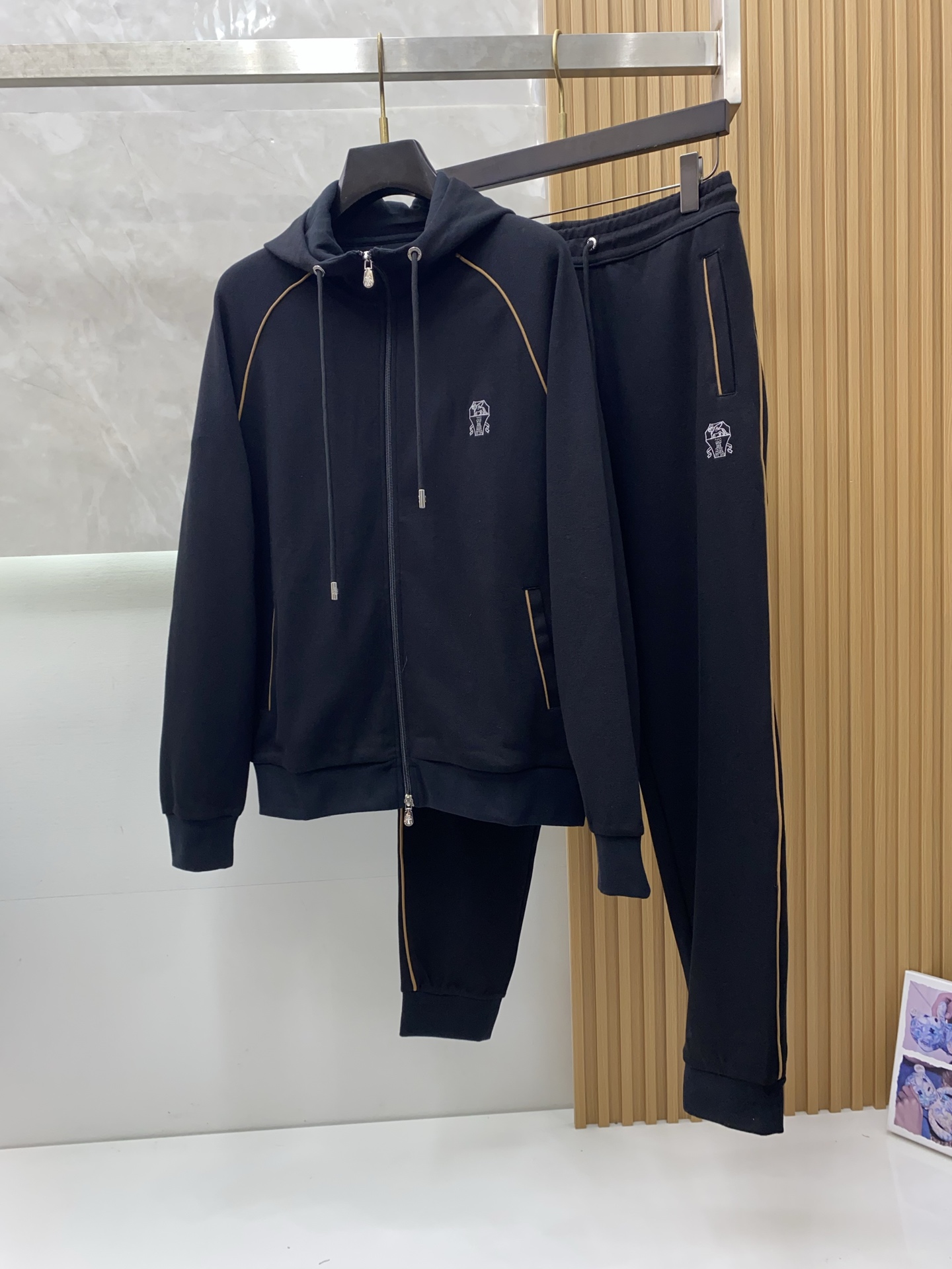 NO:568738,BC Clothes Pants New Suit Fall/Winter hooded zipper jacket and leggings trousers are in perfect harmony. Metallic walls and warm light are intertwined to outline a low-key but high-end aura that cannot be ignored. The exquisite embroidered logo on the chest quietly tells the brand gene, and the zipper pockets on both sides are both practical and contoured. The set demonstrates 'power in relaxation'. The hooded design is three-dimensionally tailored to fit the shoulders and neck, and is windproof and calm.  Functional aesthetics, double-sided zipper pockets on the top and bottom, neat storage without sacrificing the sense of style. Comfortable philosophical drawstring waistband and leggings, to accommodate the body shape and make a stylish move. Scenarios are unlimited: private clubs, urban walks, long journeys, calmly cope with multiple occasions. When Italian ingenuity meets Oriental tranquility - Brunello Cucinelli reshapes the autumn and winter sports narrative with silent luxury.   Size 48-56MLXLXXLXXXL, (model 173,143,, brunello cucinelli, jackets & coats, hats, alexander wang19860909BC 衣服 裤子 新品套装秋冬新品连帽拉链外套与束脚长裤默契相承,金属质感墙面与暖光交织,勾勒出低调却不容忽视的高级气场.胸前精致刺绣徽标悄然诉说品牌基因,双侧拉链口袋兼顾实用与轮廓感,一套演绎「松弛中的力量」. 连帽设计立体剪裁贴合肩颈,防风亦显从容气度 功能美学上下装双侧拉链口袋,利落收纳不减造型感 舒适哲学抽绳腰头与束脚裤型,包容身形且步履生风 场景无界私人会所、都市漫步、远行旅途,从容应对多元场合 当意大利匠心遇见东方静谧——Brunello Cucinelli 以无声奢华重塑秋冬运动叙事. 码数48-56MLXLXXLXXXL,（模特173,143,,brunello cucinelli,jackets & coats,hats,alexander wang,Men's clothing