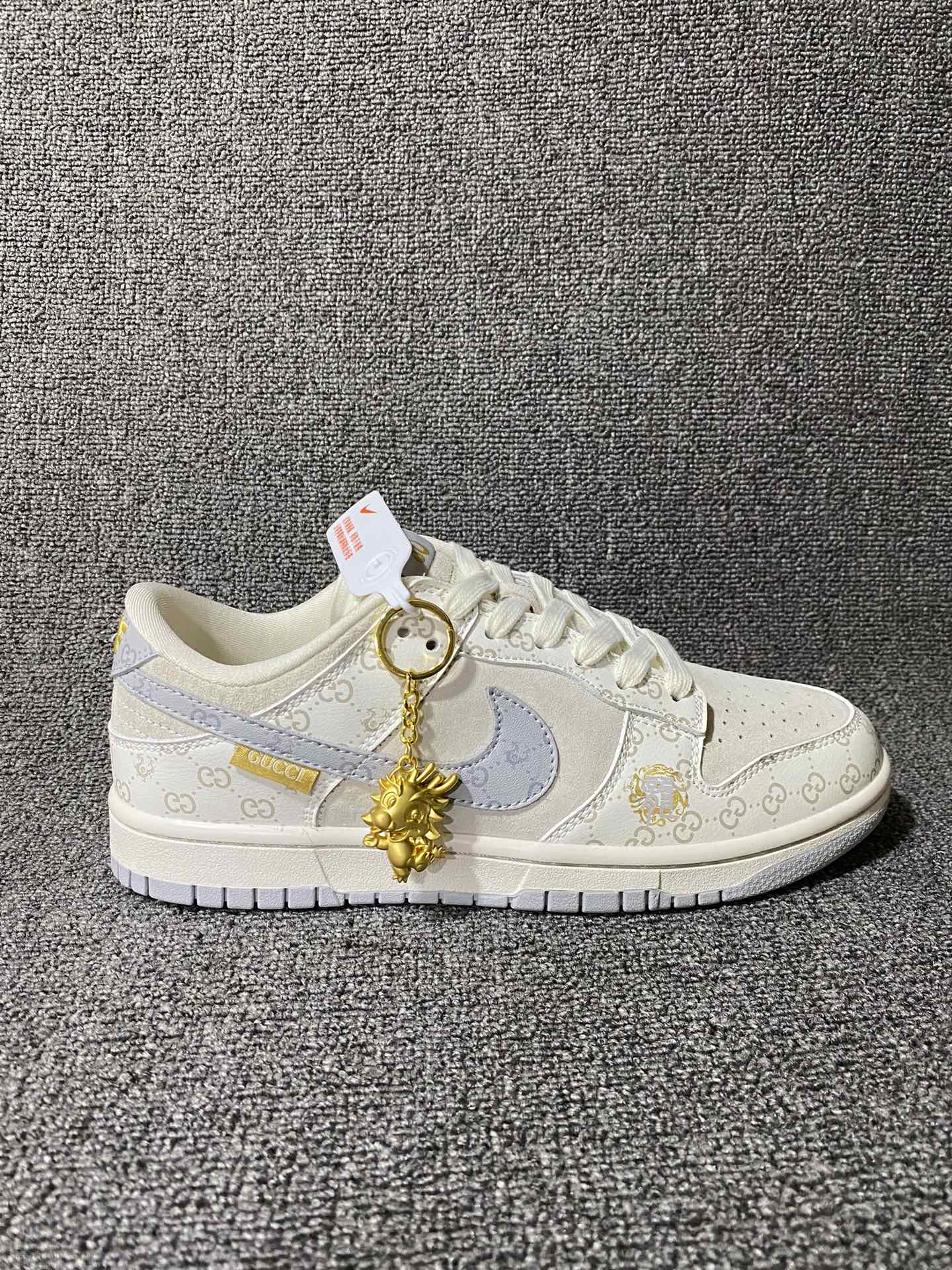 古驰联名-灰龙 海外官方同步发售,耐克Nike Dunk Low 古驰Gucci联名创作.中国龙为主题,融入意大利设独特的创意和革新,鞋面采用小牛皮印压Gucci LOGO,鞋身搭配头层猪八革面料,再点缀上繁体字"龍",鞋盒采用毛笔字龍加上扇形纹路,更具中国古典风(附带幸运龙镀金挂饰一枚) 货号:FC1688-159