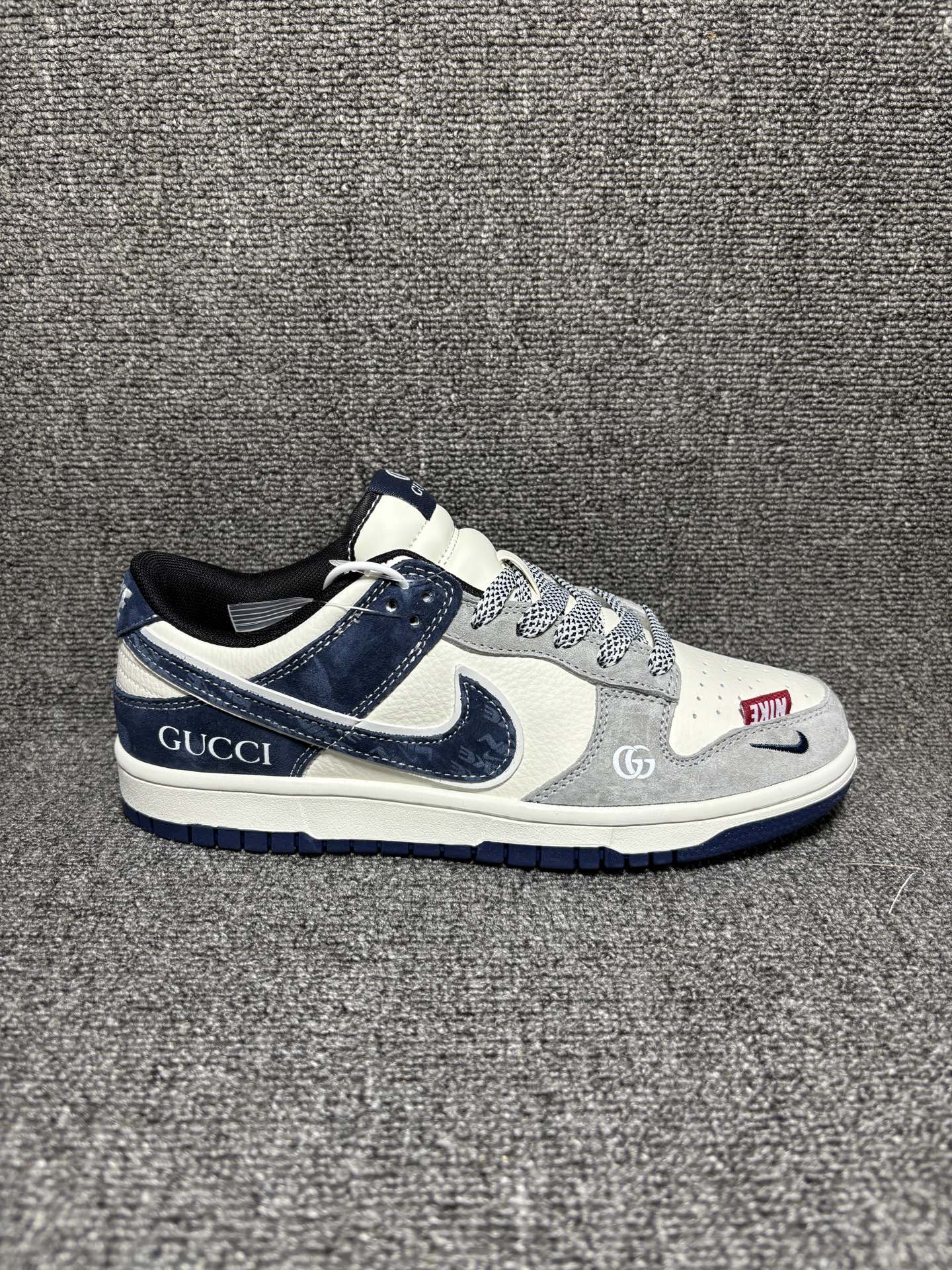 海外高端定制限量发售!「GUCCI × Nike Dunk 联名限定」 当经典Dunk遇上双G老花,复古与奢感碰撞出高级感.白灰藏蓝三色拼接,麂皮与荔枝皮层次分明,鞋身GUCCI刺绣与双G标识低调彰显身份,细节处的织带与金属挂饰更添精致.上脚即是行走的时尚名片,通勤、出街都能轻松hold住全场,是潮人鞋柜里不可错过的收藏级单品. 货号:XZ5899-107