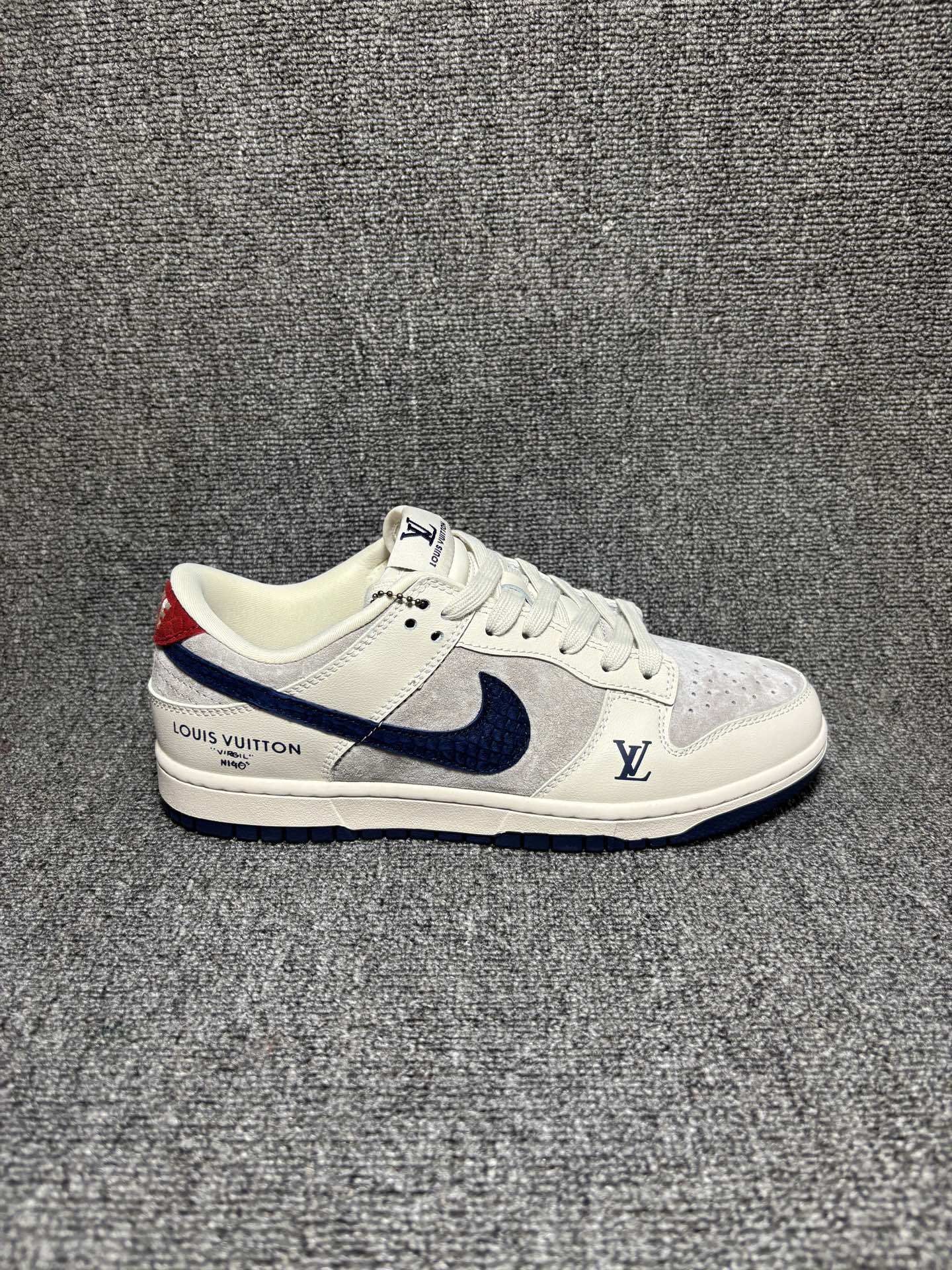 复古街头王者 SB DUNK LOW 米白与浅灰拼接鞋面质感高级,藏蓝Swoosh搭配金属LV挂饰,后跟红标与侧部LV标识呼应联名设计,Dunk经典低帮版型上脚显高显瘦,橡胶外底防滑耐磨,无论是搭配牛仔裤还是工装裤,都能轻松穿出潮流博主范儿. 货号:XX3168-122