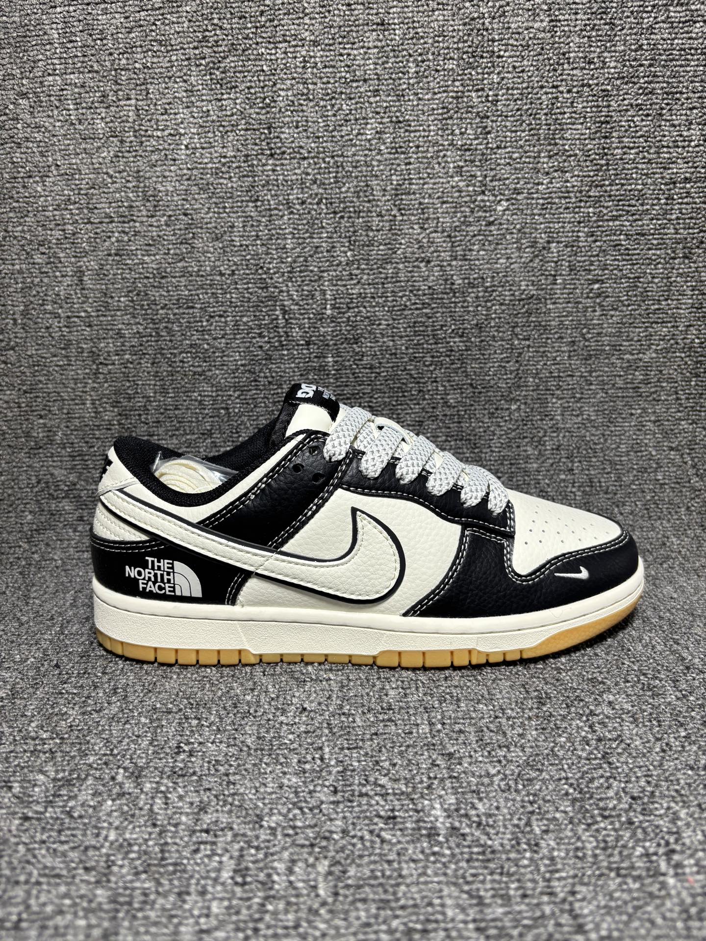 黑白撞色 街头潮搭 SB DUNK LOW 经典低帮版型自带复古街头气场,黑白荔枝纹鞋面质感拉满,双勾设计与后跟TNF联名标识细节感爆棚,米白中底搭配生胶外底,兼顾抓地力与复古调性,百搭不挑风格,上脚秒变潮酷达人,轻松拿捏各种穿搭场景. 货号:XX3168-119