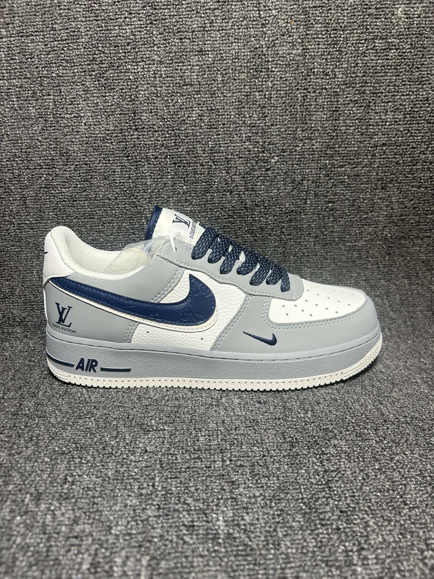 高级灰调 质感拉满 AIR FORCE 1 采用灰白撞色搭配藏蓝压纹Swoosh,LV标识低调彰显质感,荔枝纹皮革鞋面细腻耐穿,低帮版型利落不臃肿.黑白编织鞋带搭配同色系缝线,鞋侧双勾设计层次丰富,厚底缓震脚感舒适,通勤、出街都能轻松hold住,百搭又自带高级氛围感. 货号:LF6688-002