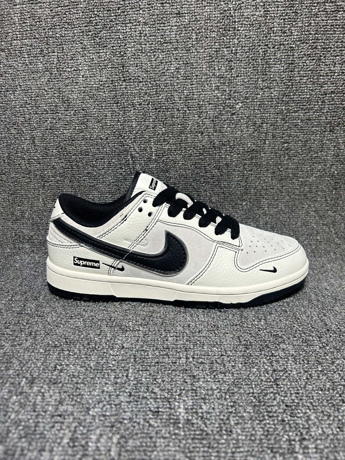 复古米黑 街头神鞋 NIKE SB DUNK LOW 以米白麂皮拼接荔枝纹皮革打造复古质感,黑边走线勾勒层次,多勾设计搭配Supreme标识,低调又自带街头辨识度.低帮鞋型利落百搭,厚底脚感舒适,无论是日常通勤还是搭配潮装都能轻松驾驭,轻松拿捏复古潮流氛围. 货号:XX3168-302