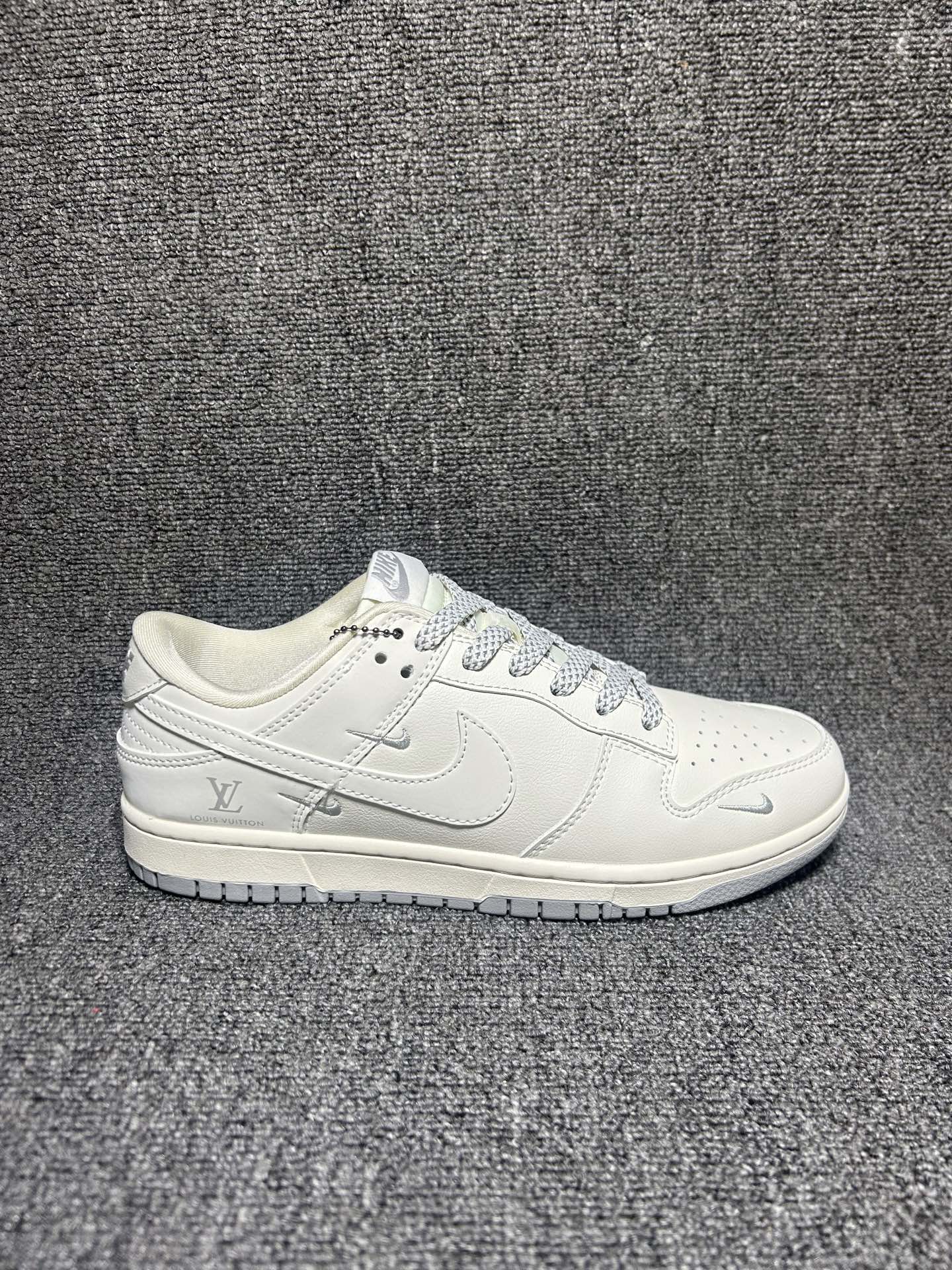 米白LV联名 质感拉满 NIKE SB DUNK LOW 采用米白荔枝纹皮革打造鞋身,细腻柔软自带高级柔光质感,鞋身多枚银色迷你Swoosh与后跟LV标识低调彰显联名身份,经典低帮版型适配各种裤型,上脚轻盈无负担,日常穿搭轻松穿出潮流氛围感. 货号:XX3168-180