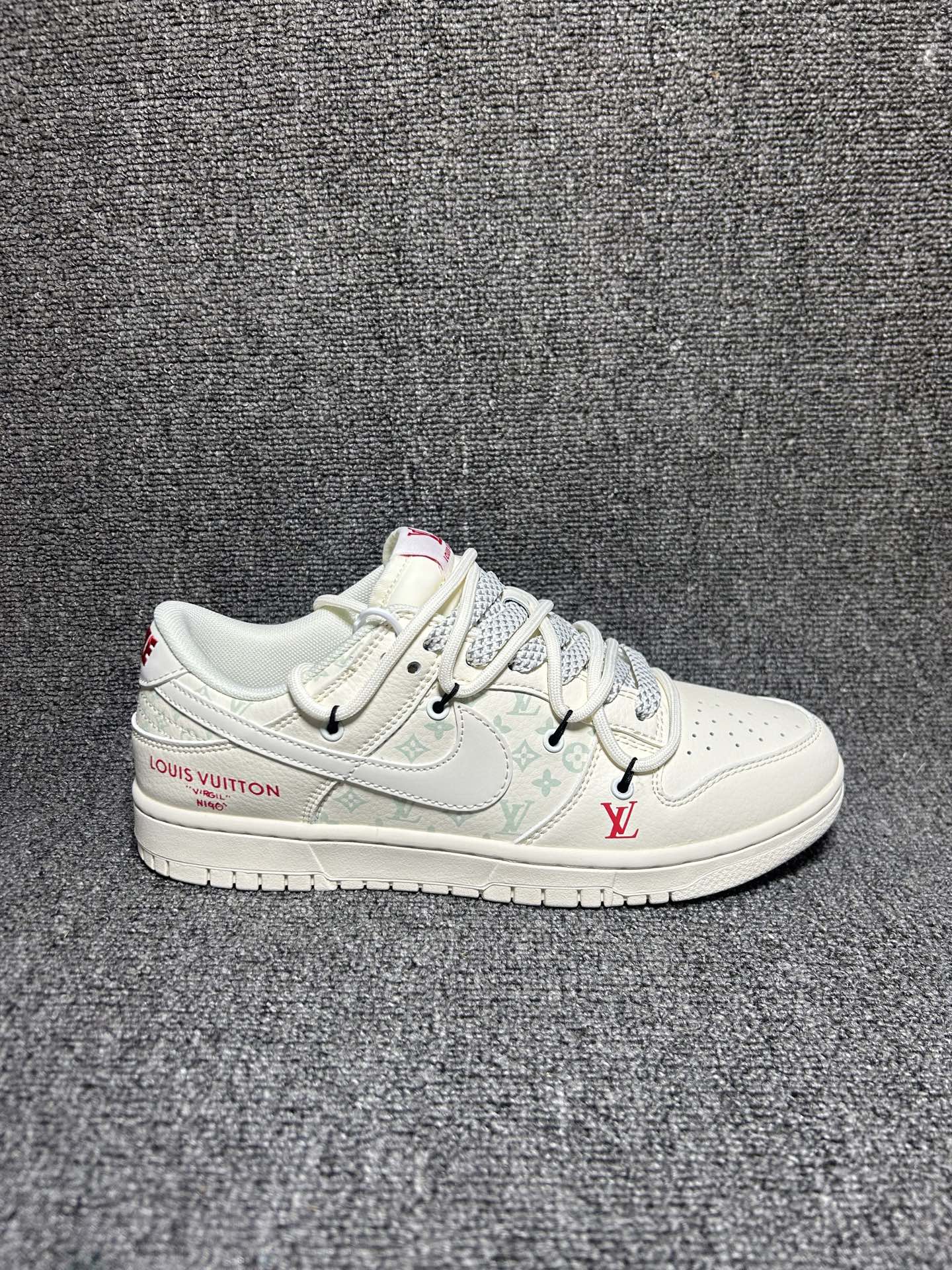 白调奢潮,经典重塑|Nike Dunk Low x LV 联名款 纯白主调的Nike Dunk Low遇上Louis Vuitton的奢雅基因,这双CX5050-Y52直接把奢潮融合的高级感拉满!奶白色的皮革鞋身质感细腻,浅调LV老花图案低调交织,红色的LV标识与“LOUIS VUITTON”字样作为点缀,瞬间点亮视觉,撞色鞋带与细节挂饰更是为鞋款增添了设计巧思.Dunk Low的经典低帮鞋型保留了利落的街头线条与舒适脚感,LV的奢品元素则为这双街头鞋款注入了高阶时尚感,每一处细节都藏着联名的独特匠心.不管是日常搭配打造简约高级的造型,还是作为收藏级的潮流单品,这双鞋都能成为你鞋柜里的“白月光”,让你轻松拿捏奢潮结合的穿搭腔调.