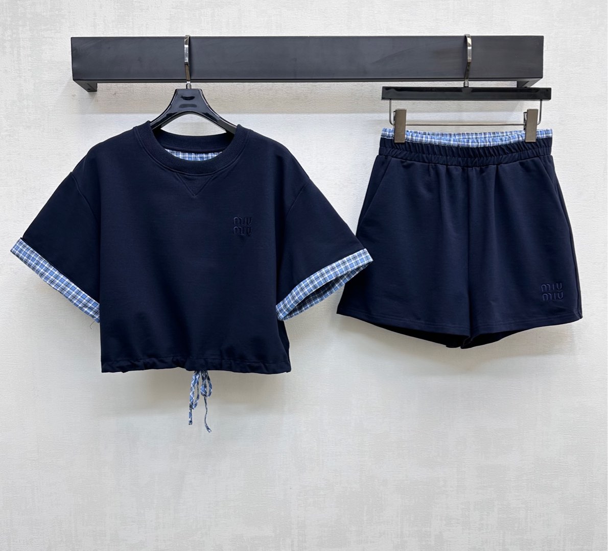 NO:423260,Miumi*2025 new product on-shelf splicing plaid set customized YB imported native cotton material breathable and comfortable. The cuffs are spliced ​​blue plaid shirt fabric, the same details as the waist, and the hem drawstring is easy to adjust and waist, adding a sense of styling. The chest leg side is decorated with iconic embroidered letter logo to highlight the brand tone. The surface and auxiliary materials development. Short-sleeved tops are cut in the same series. Complete sets of wear and reduce age and youthful college style. High-end version,,miumiu, shorts,shirts,T-shirt,alexander wang19860909Miumi*2025新品上架拼接格纹套装定制YB进口原生全棉材质 透气舒适 袖口沿用拼接蓝格衬衫面料 与腰头细节相同更显协调 下摆抽绳便于调节收腰处理 增添造型层次感 胸前腿侧点缀标志性刺绣字母徽标 彰显品牌调性 面辅料开发 短袖上衣同系列短裤剪裁 成套穿搭减龄青春学院风  高版本,,miumiu,shorts,shirts,T-shirt,alexander wang,Women's clothing