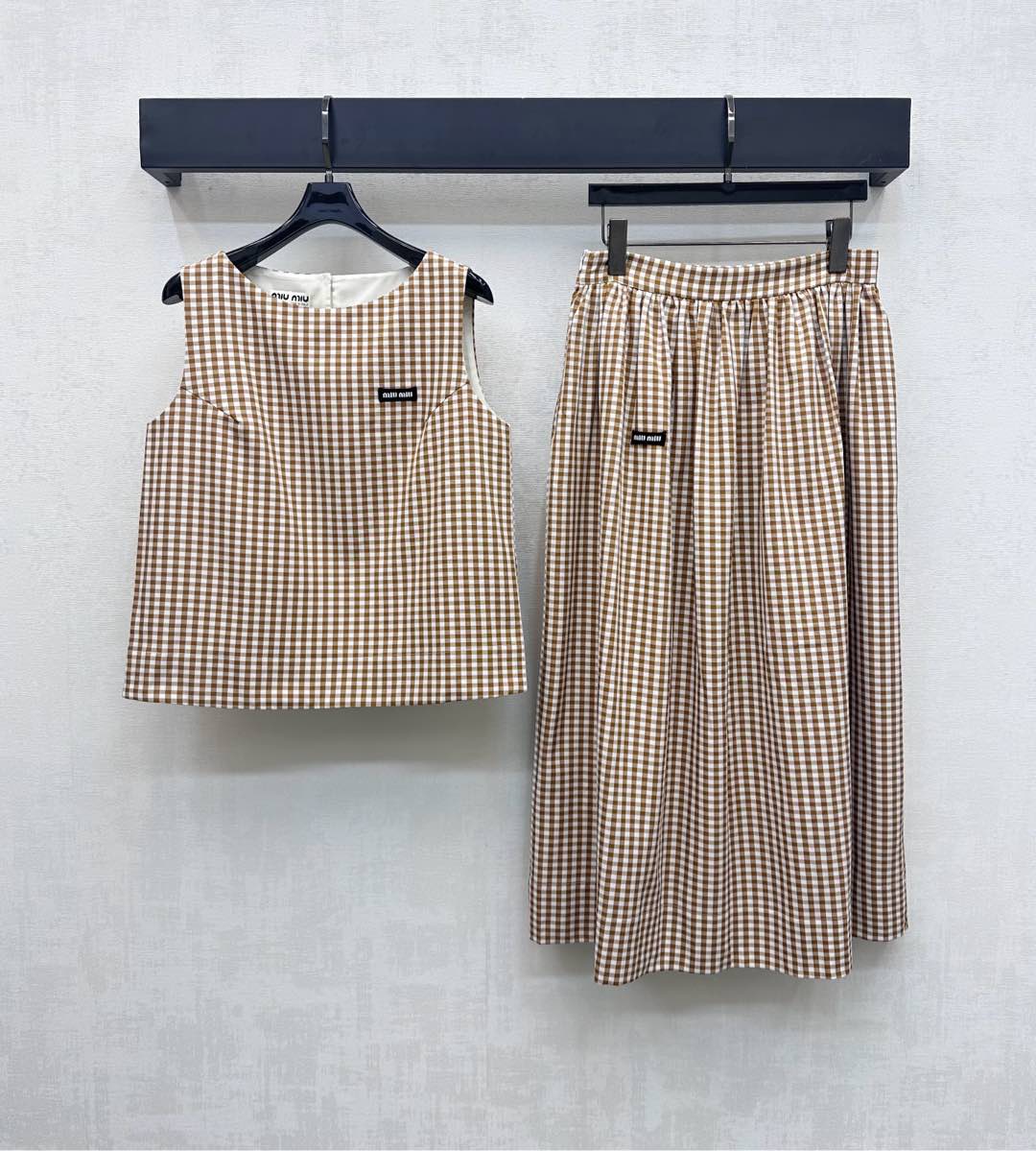 NO:457160,Miumi*2025 new product plaid vest skirt set customized YB imported twill material, sleek, breathable and stylish, full of two-color plaid elements, simple and fashionable, iconic letter logo decoration on the chest, highlighting the brand tone, surface and auxiliary materials development, short vest tops, high waist mid-length skirt set, create a relaxed vacation, logo details echo up and down, umbrella-shaped skirts modify the body shape, add layering of the styling, presenting a casual and literary style, full of top-body fashionable vacation feeling, high-version, miumiu, skirts, alexander wang19860909Miumi*2025新品上架格纹背心半裙套装定制YB进口斜纹绸材质 垂顺透气有型 通体满铺两色格纹元素简约时尚 胸前点缀标志性字母徽标装饰 彰显品牌调性 面辅料开发 短款背心上衣高腰中长半身裙套装 打造度假松弛感 徽标细节上下呼应 伞状裙摆修饰身型 增添造型层次感 呈现随性文艺的穿搭风格 成套上身时髦度假感十足   高版本,,miumiu,skirts,alexander wang,Women's clothing