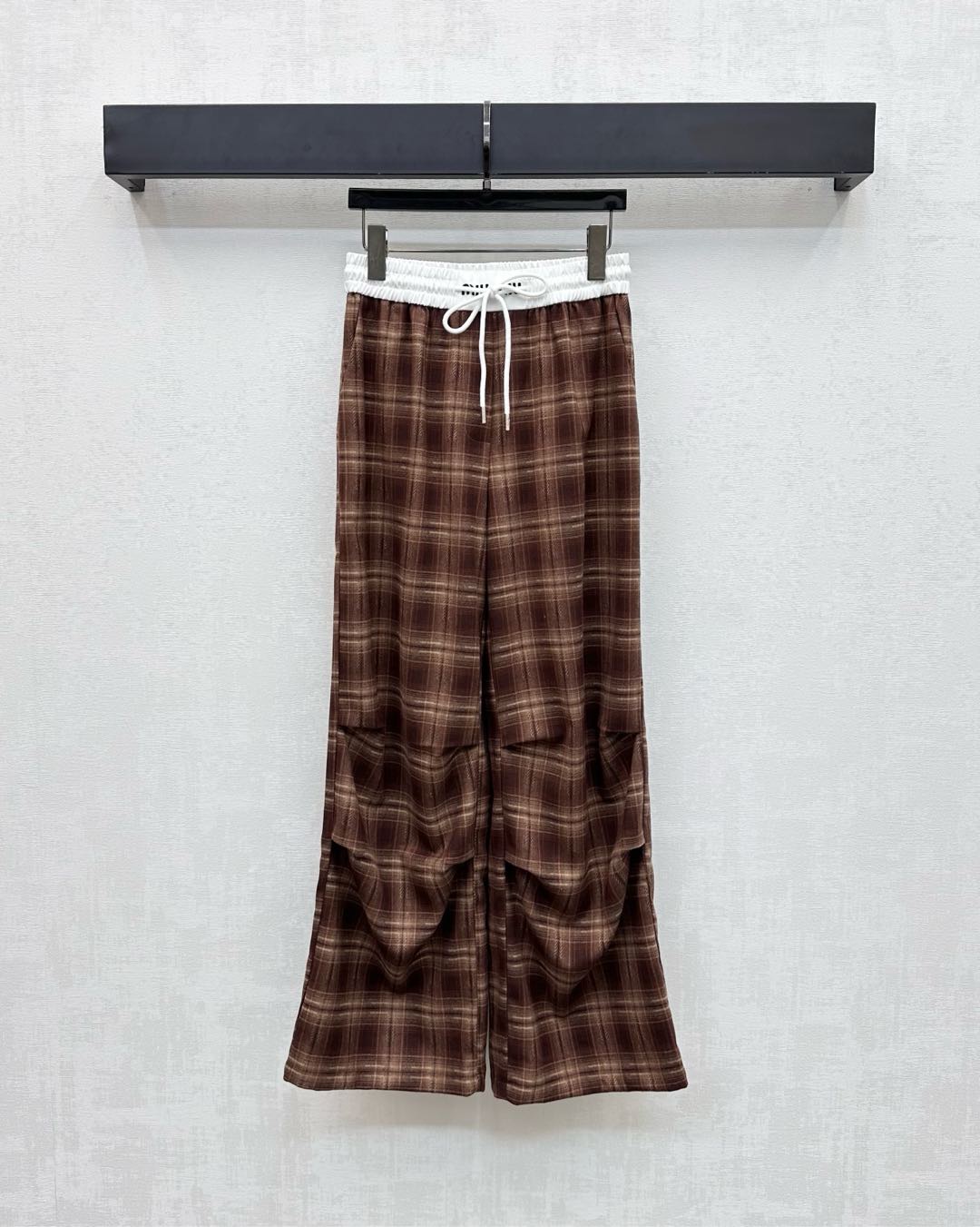 NO:500406,Miumi*2025 new product is on the shelves of plaid pleated drawstring trousers customized with YB imported polyester cotton material. It is soft and skin-friendly, with stronger draping. High-quality plaids are covered with plaids. It is designed with white edge drawstrings on the waist. It is decorated with iconic letter embroidery logos to highlight the brand tone. The pleats at the knees are strong, making the outfit more inclusive. It does not pick on the figure and adds a sense of styling. The surface and auxiliary materials are developed. High-waisted wide-leg trousers are cut. The upper body is fashionable and relaxed. Wearing a fashionable and fashionable dressing style. High version 2 colors,,miumiu,alexander wang19860909Miumi*2025新品上架格纹褶皱抽绳长裤定制YB进口涤棉材质 质感柔软亲肤 垂感更强 品相高级 通体格纹满铺 配合腰间以白色包边抽绳设计 穿插标志性字母刺绣徽标装点 彰显品牌调性 膝盖处褶皱工装感强烈 让穿搭更加包容 不挑身材 增添造型层次感 面辅料开发 高腰阔腿长裤剪裁 上身洋气松弛 穿出时髦流行穿搭风格 高版本2色,,miumiu,alexander wang,Women's clothing